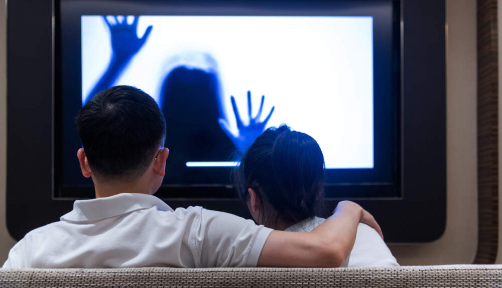 A couple watches a horror movie. (Baona/Getty Images)