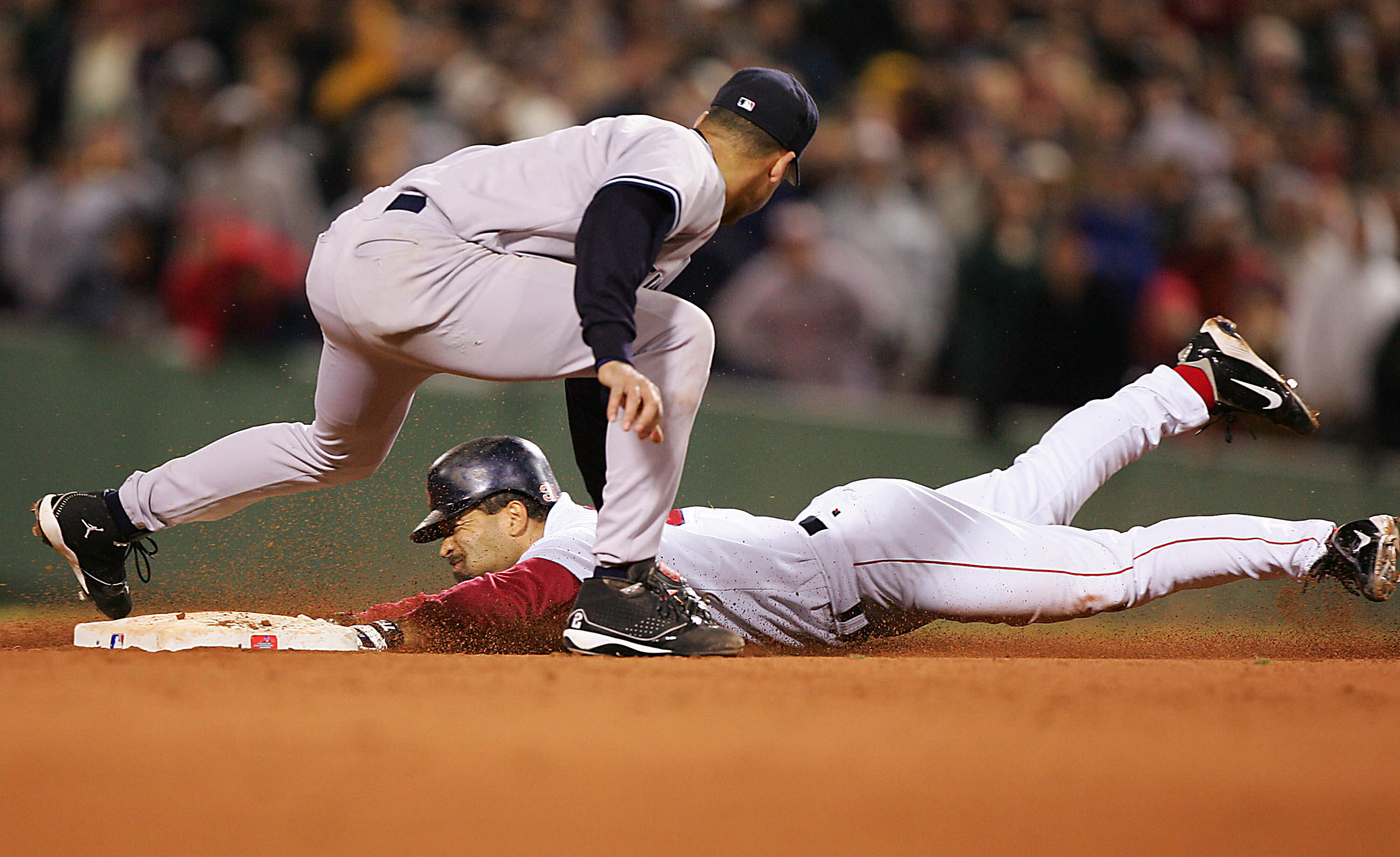 Dave Roberts of the Boston Red Sox steals second base while shortstop Derek Jeter of the New York Yankees applies the tag in the ninth inning during game four of the American League Championship Series on October 17, 2004 at Fenway Park in Boston, Massachusetts. (Jed Jacobsohn/Getty Images)