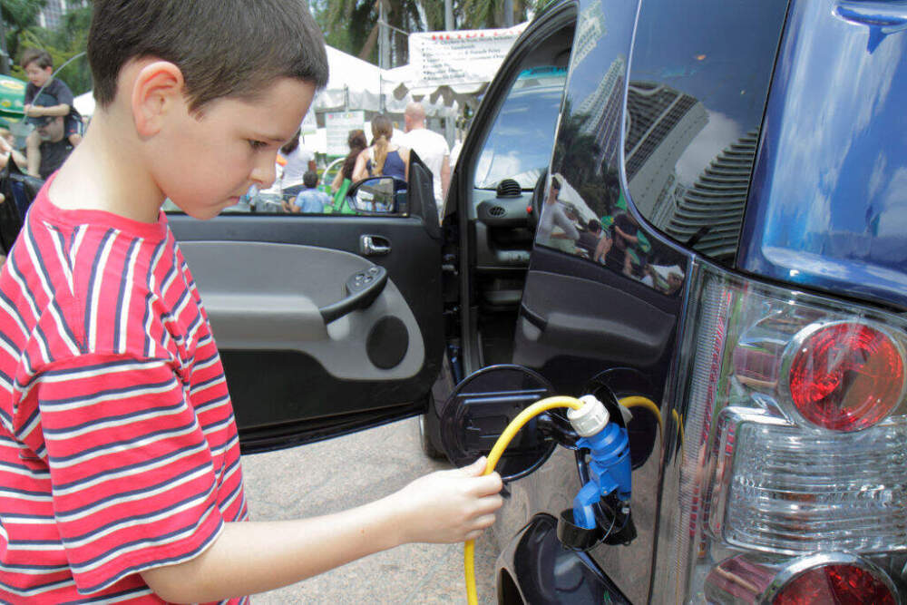 A boy examines an electric car at the Miami Goin' Green, Earth Day event. (Jeff Greenberg/Universal Images Group via Getty Images)