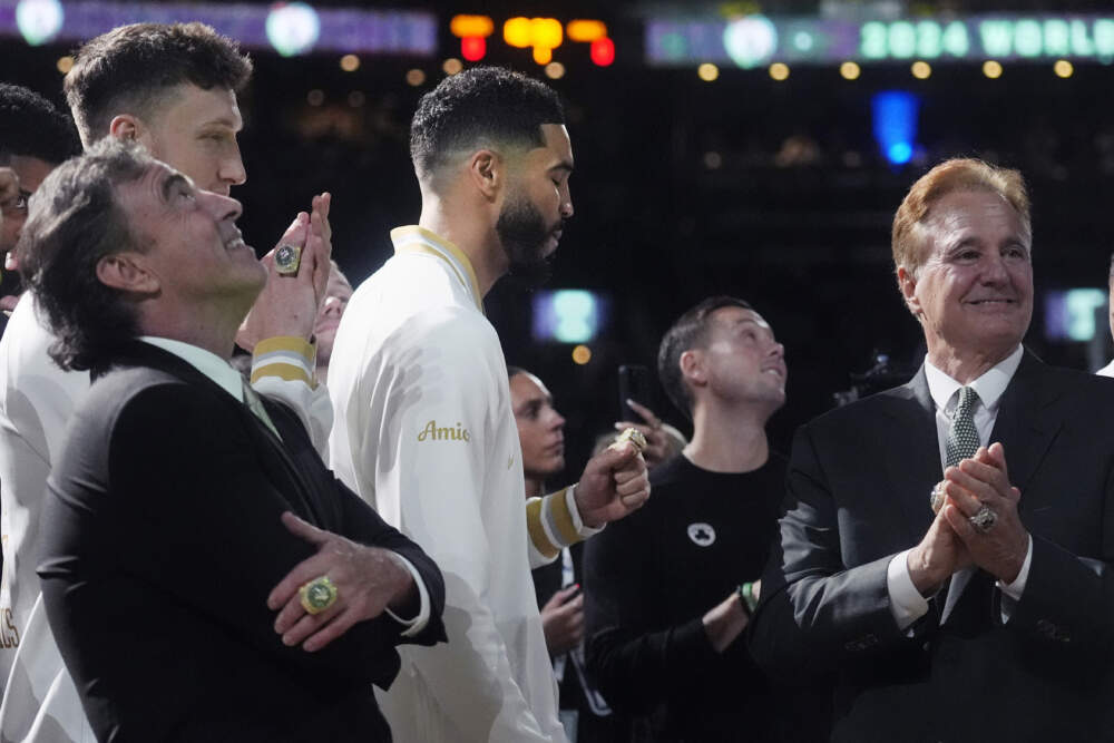 Boston Celtics forward Jayson Tatum, center, admires his ring as the 2024 World Championship banner is raised prior to the game against the New York Knicks. With Tatum are team owners Wyc Grousbeck, left, and Steve Pagliuca. (Charles Krupa/AP)