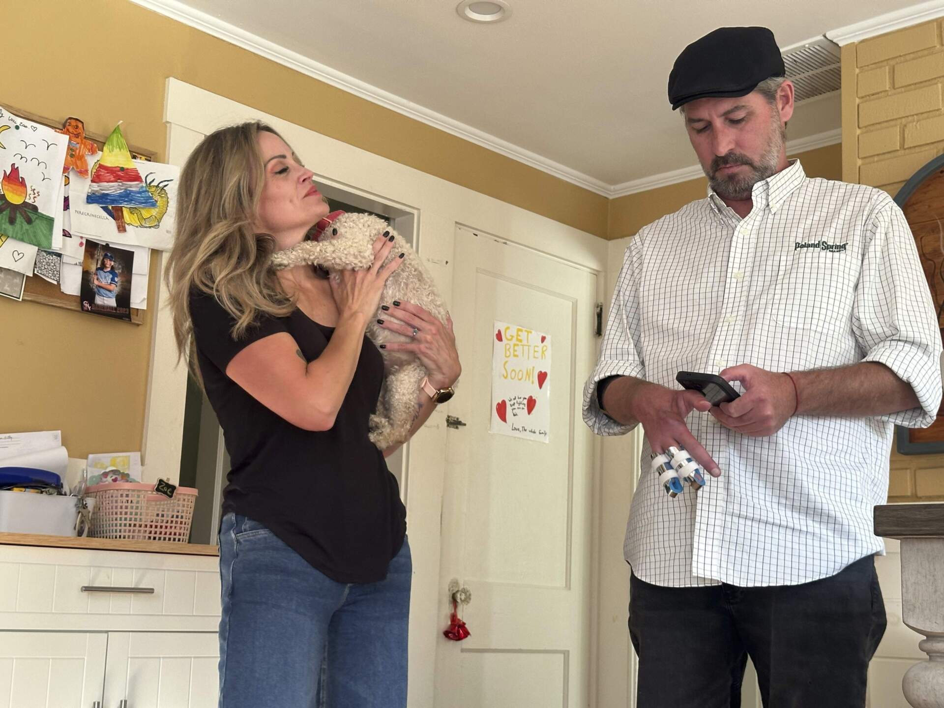 Lewiston mass shooting survivor Ben Dyer types on his phone as fiancee Keela Smith watches as they talk about the 2023 massacre and their plans for the future, Wednesday, Oct. 3, 2024, in Auburn, Maine. (AP Photo/Nick Perry)