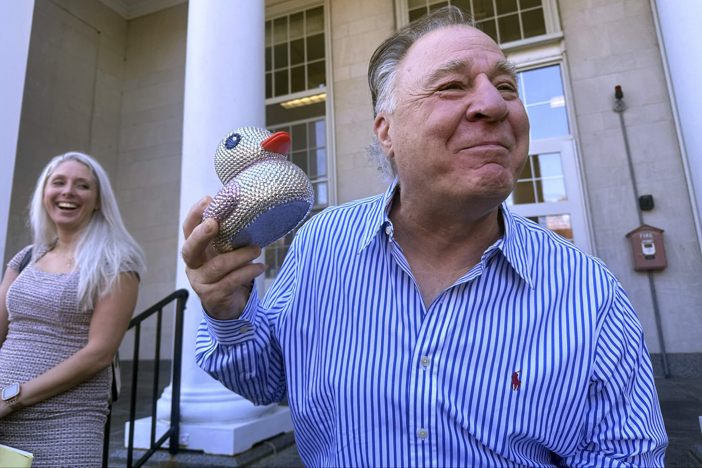 Richard Schiffer Jr., who faces witness intimidation and other charges related to the Karen Read case, holds a duck as he greets supporters on the steps outside Stoughton District Court following his arraignment, Wednesday, Oct. 23, 2024 in Stoughton, Mass. (Michael Casey/AP)