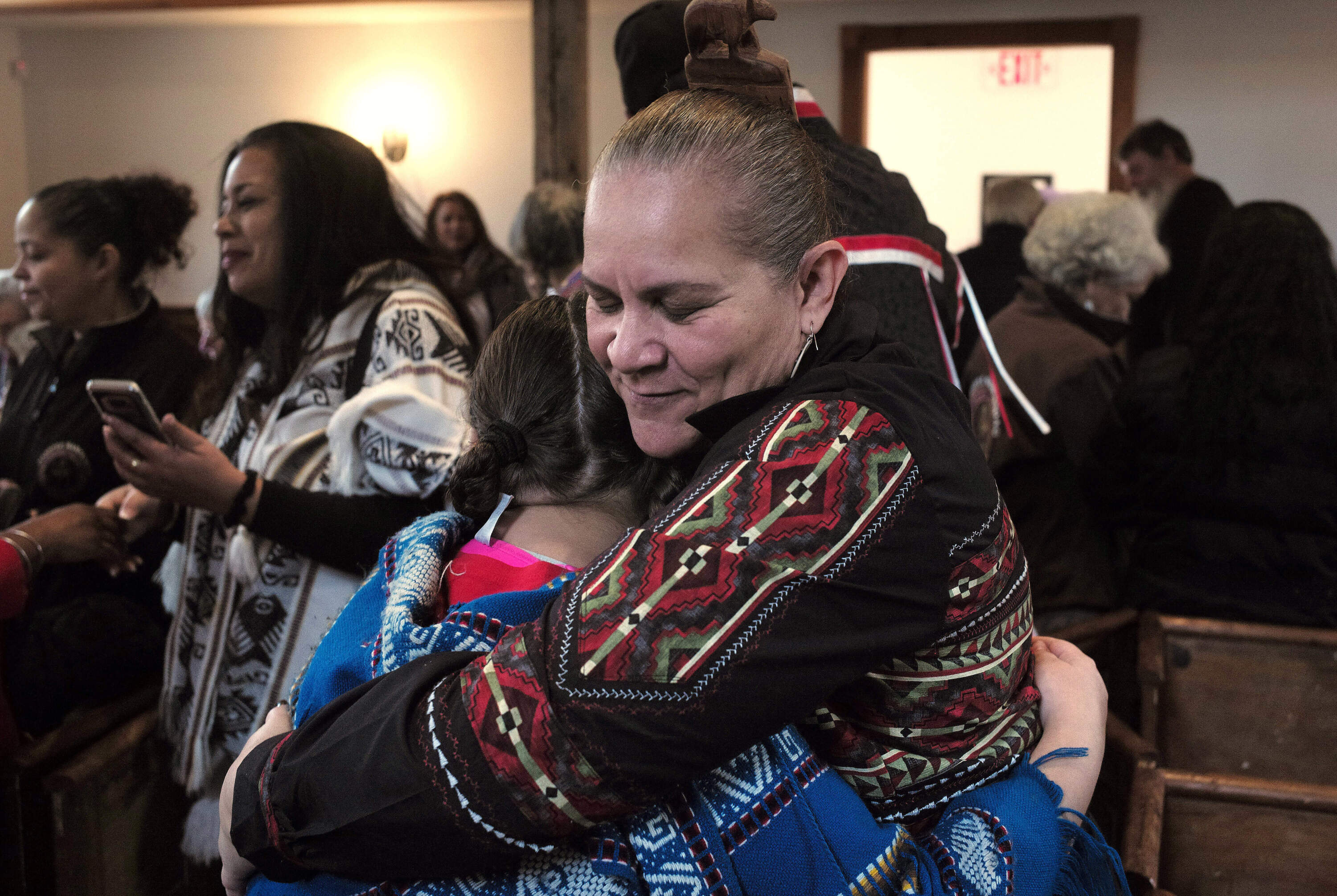 Jessie Little Doe Baird, front right, hugs a member of the audience following the "We Gather Together" celebration at the Old Indian Meeting House, in Mashpee, Mass., Nov. 18, 2017. (Steven Senne/AP)