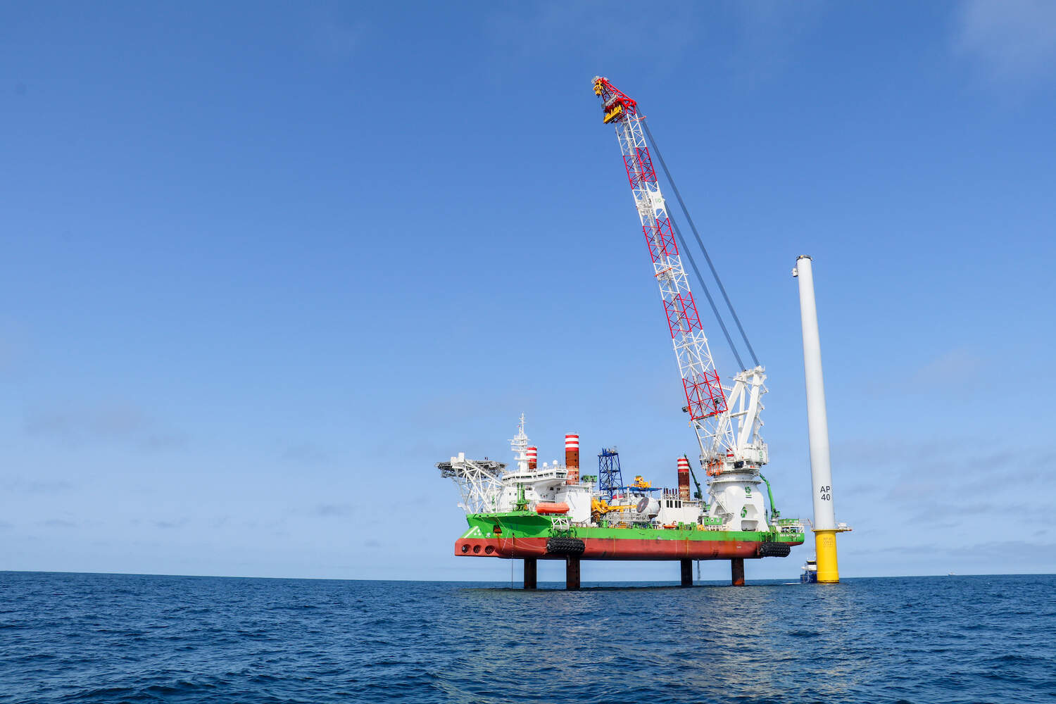 The Sea Installer, a 434-foot long "jack-up vessel" stands next to a partially constructed turbine in the Vineyard Wind project. (Liz Lerner/CAI)