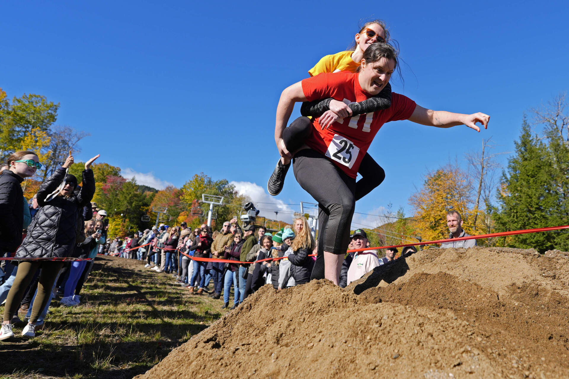 Molly Sunburn carries Megan Crowley over a sand pile during the North American Wife Carrying Championship. (Robert F. Bukaty/AP)