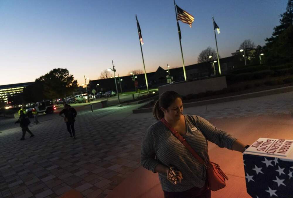 Wendy Gill inserts her absentee ballot at a drop-off box as the sun sets on Election Day outside City Hall in Warren, Mich., Nov. 3, 2020. (David Goldman/AP)