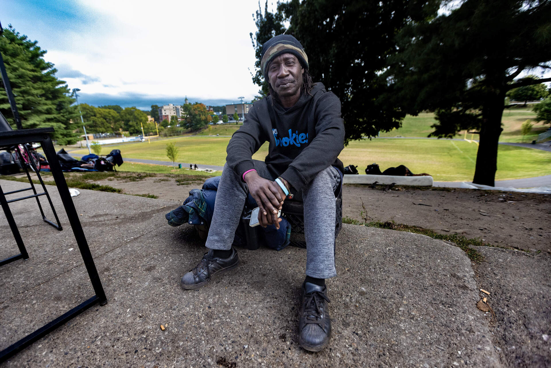 Joko Thomas sits on a sidewalk on next to South Common. (Jesse Costa/WBUR)