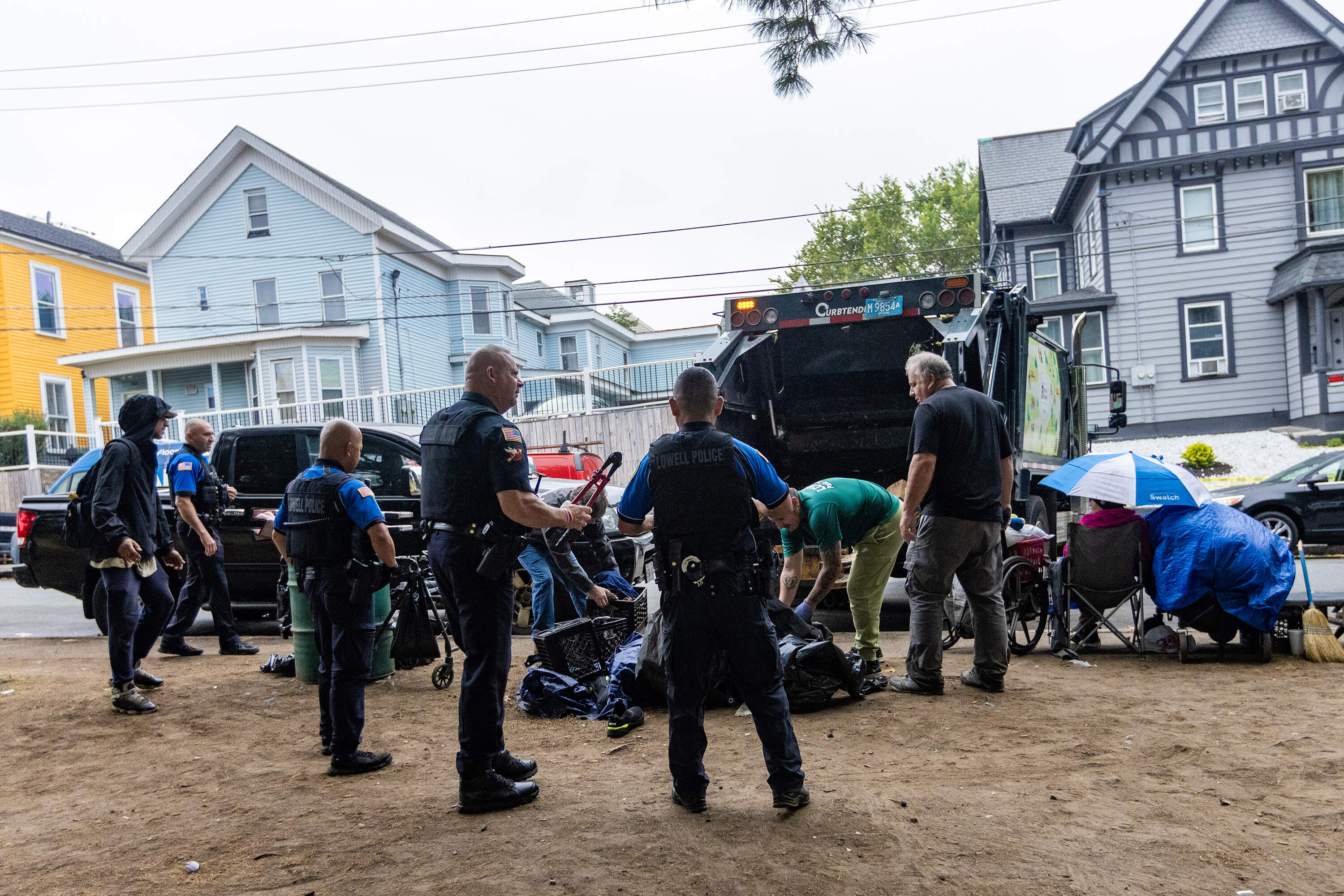 Lowell police and parks department workers conduct a weekly clean-out of belongings from the homeless encampment on South Common. (Jesse Costa/WBUR)
