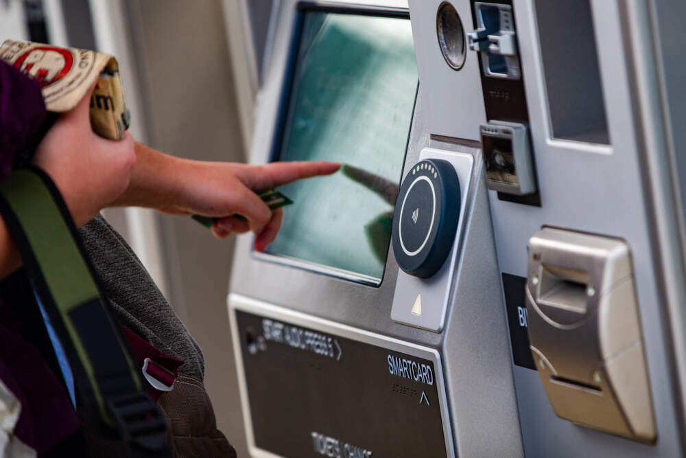 An MBTA rider uses the touchscreen on the ticket kiosk at Magoun Square station. (Jesse Costa/WBUR)