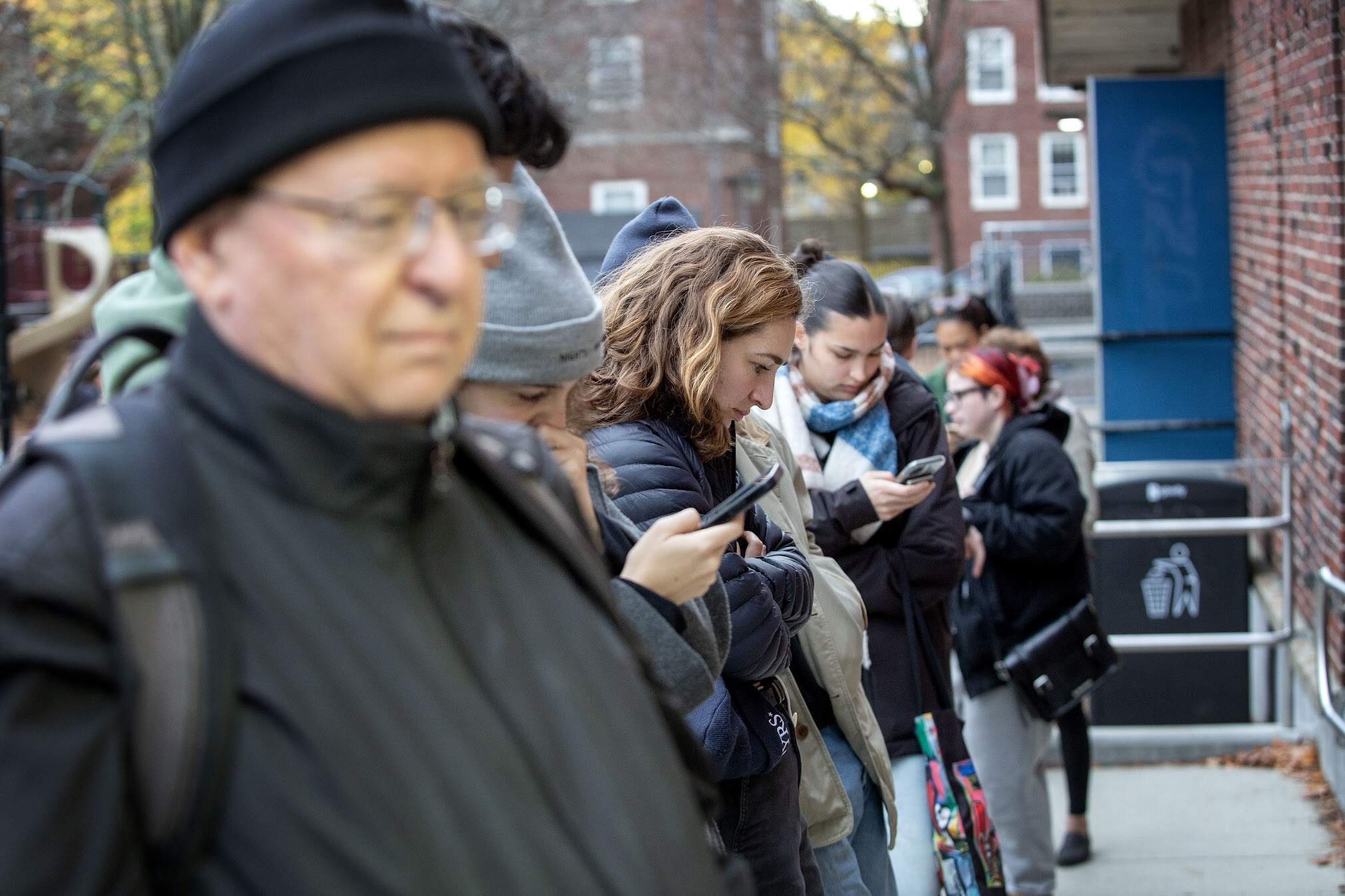 Voters line up outside the Graham & Parks School in Cambridge waiting for the doors to open on Election Day 2024. (Robin Lubbock/WBUR)