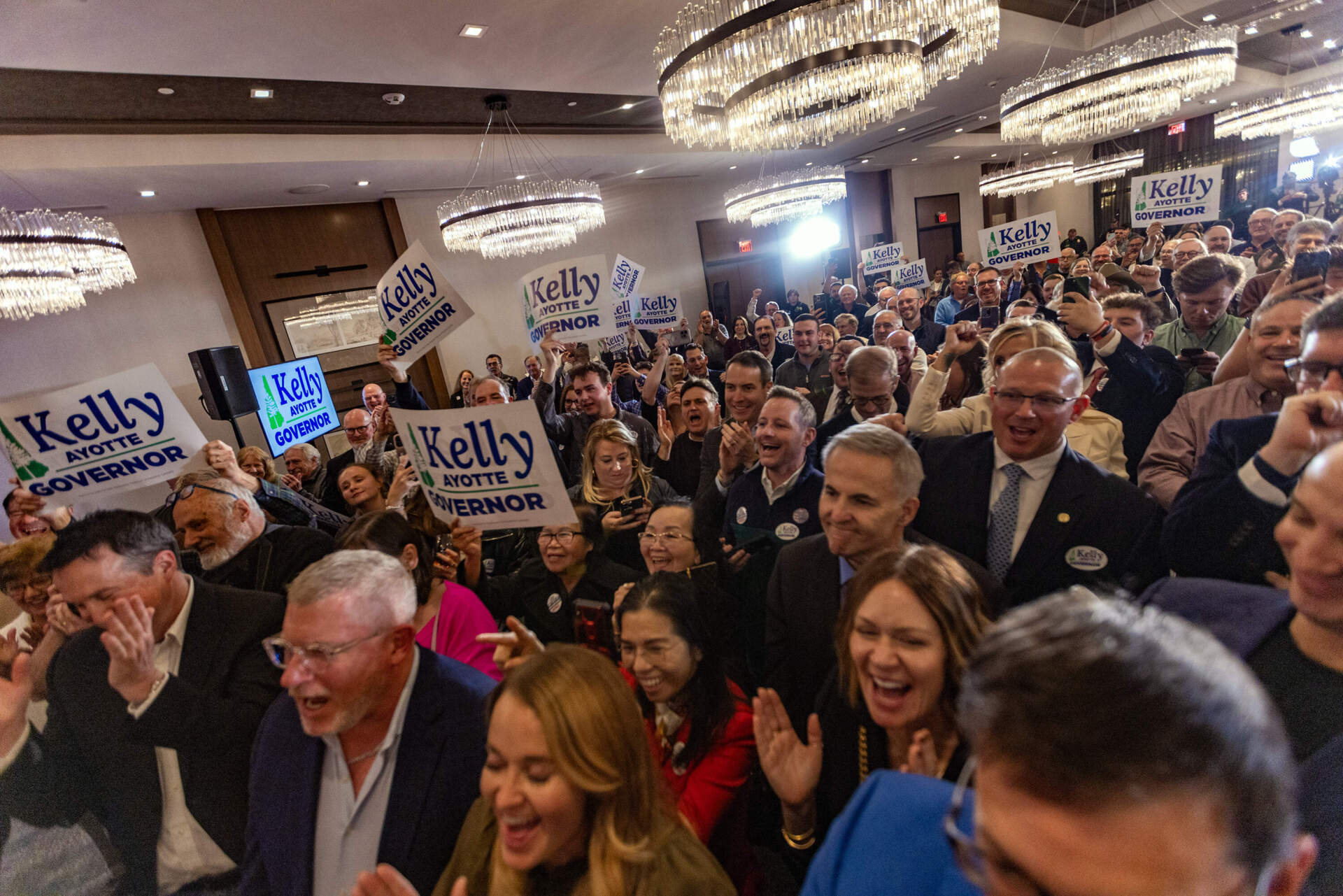 Supporters cheer for Kelly Ayotte as she addresses them after becoming the next governor of New Hampshire at the Artisan at Tuscan Village in Salem, N.H. (Jesse Costa/WBUR)