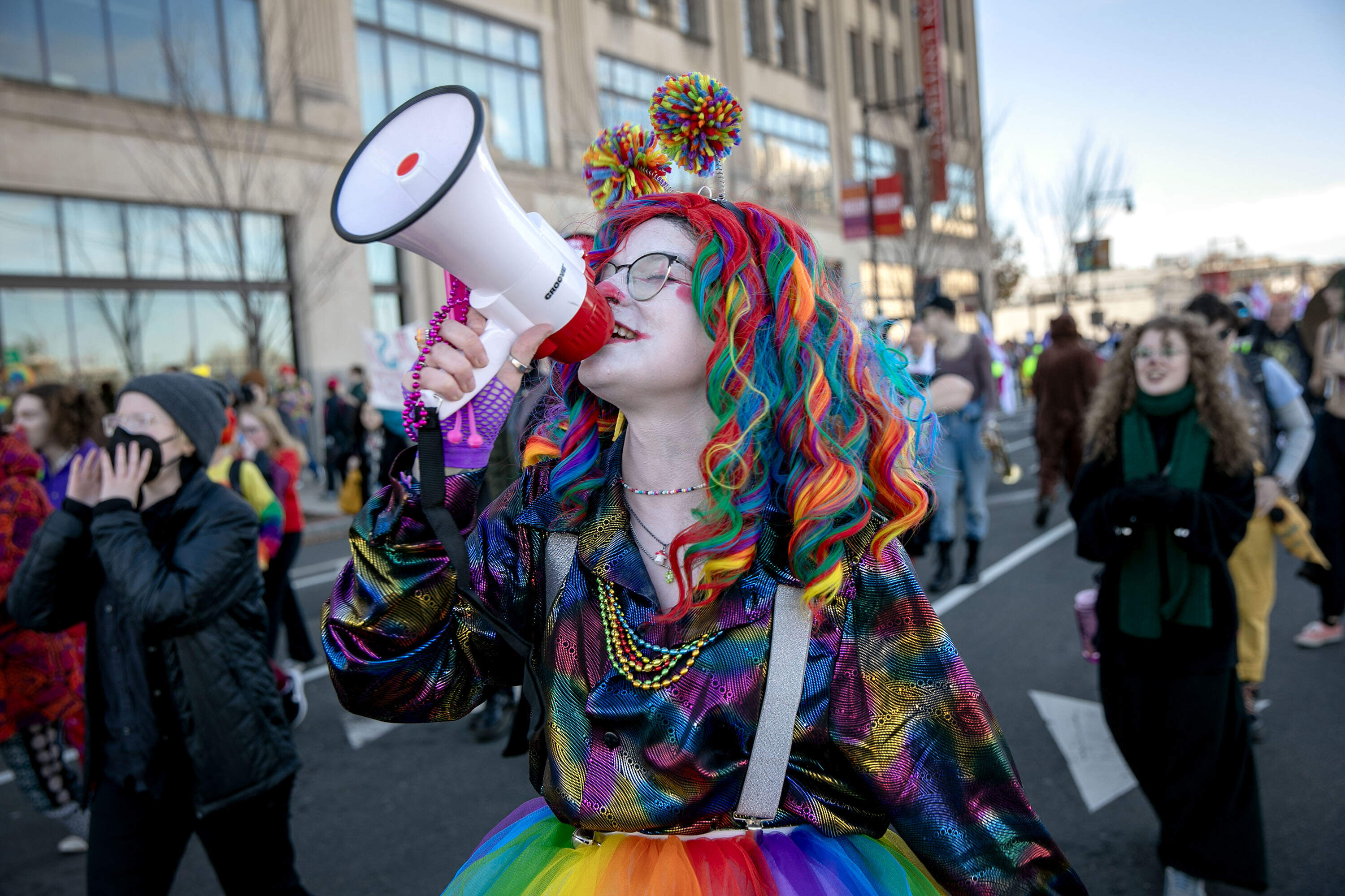 A group of counter-protesting clowns walk ahead of the anti-abortion Men's March as it proceeds down Commonwealth Ave. (Robin Lubbock/WBUR)