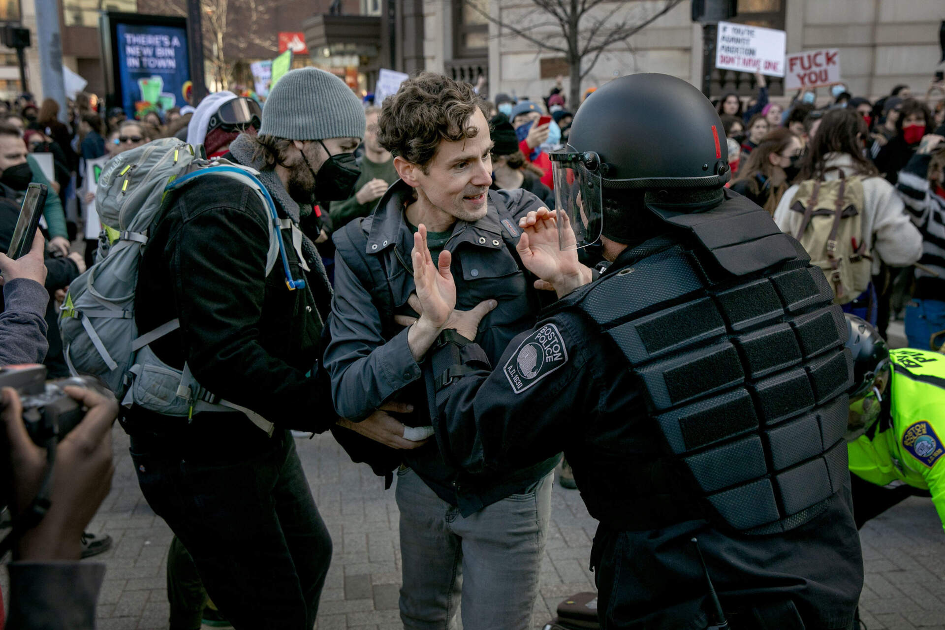 Police officers clear counterprotesters from the route of an anti-abortion march through Kenmore Square. (Robin Lubbock/WBUR)