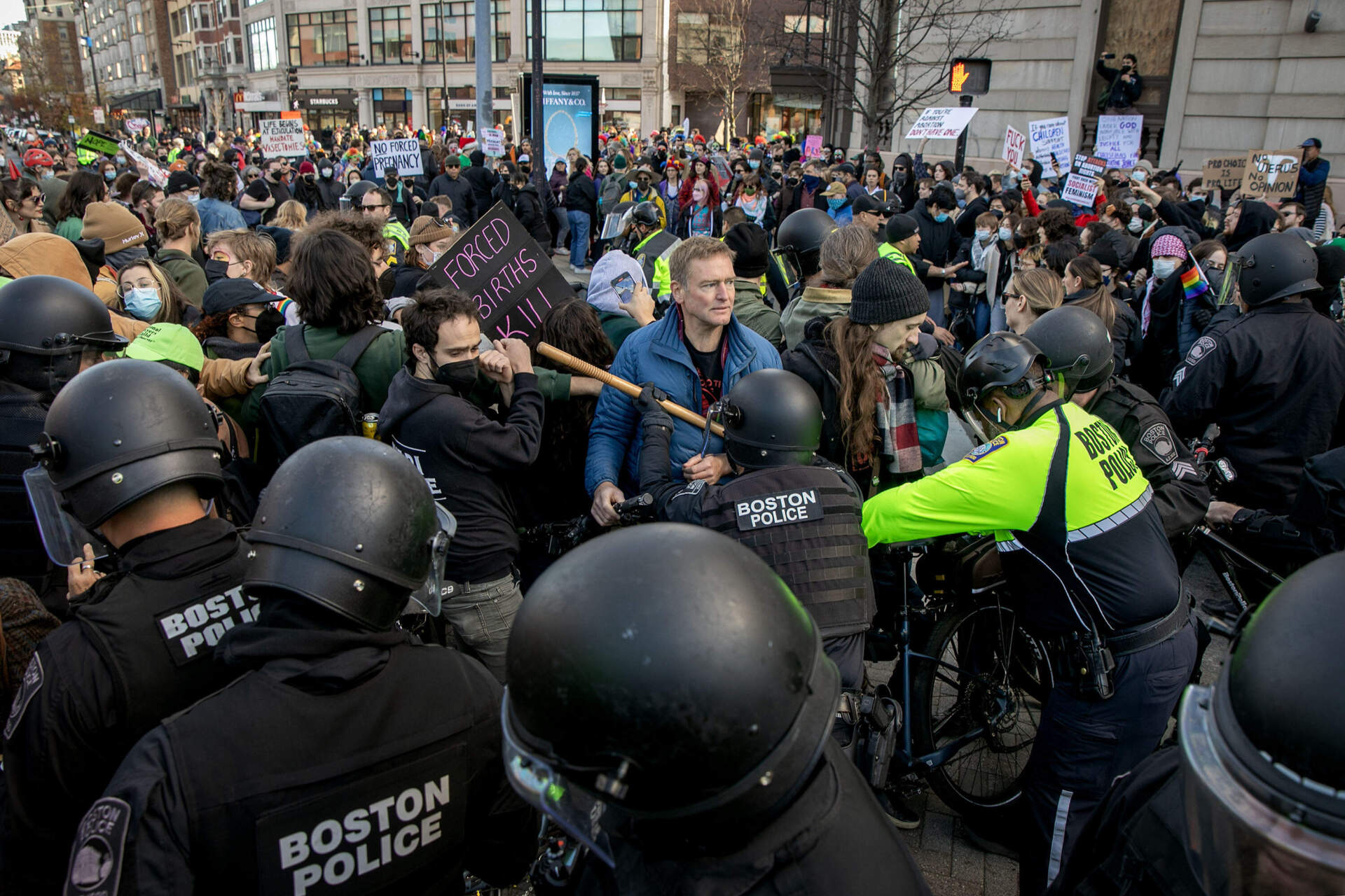 Police officers push counterprotesters away from the route of an anti-abortion march through Kenmore Square. (Robin Lubbock/WBUR)