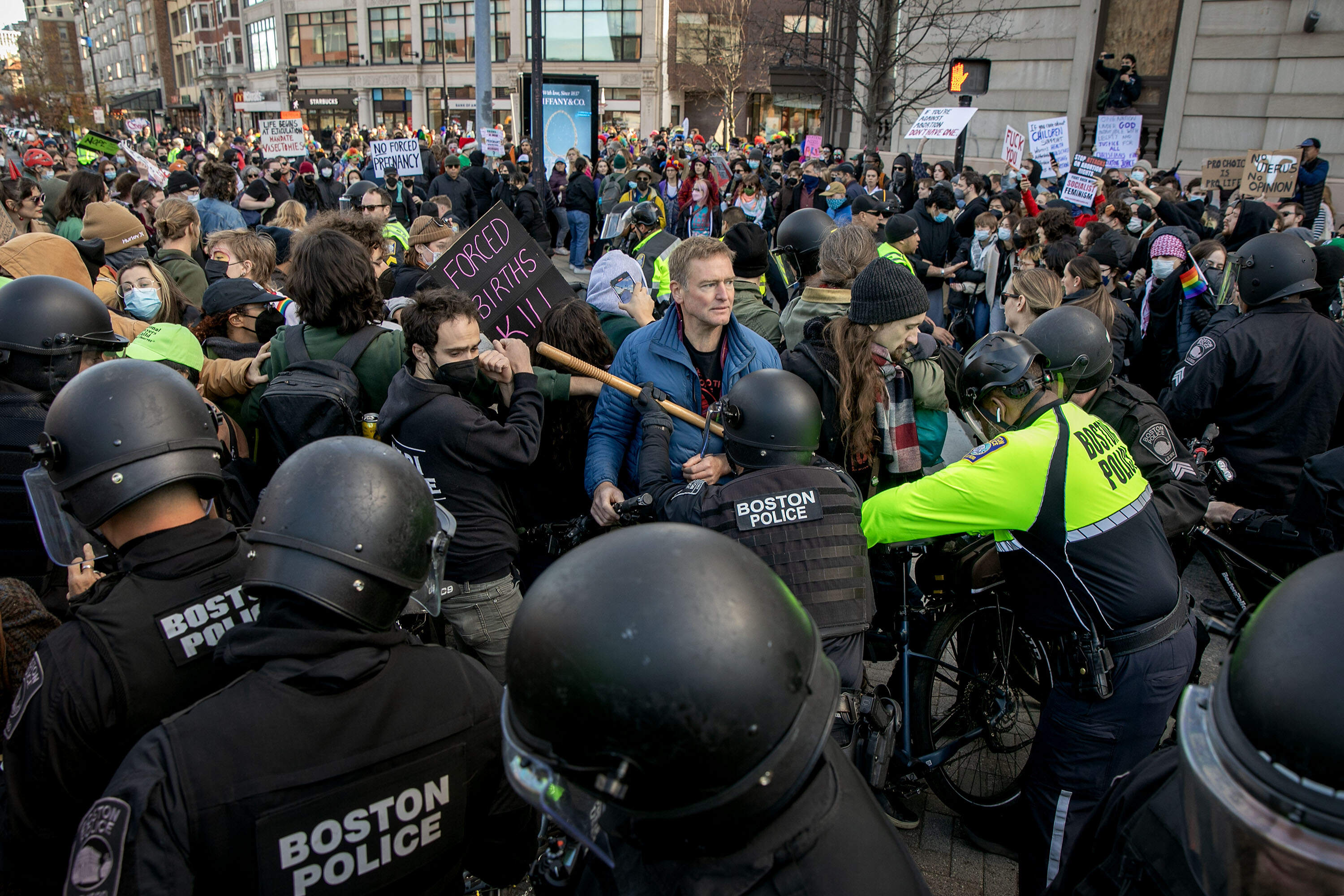 Police officers push counterprotesters away from the route of an anti-abortion march through Kenmore Square. (Robin Lubbock/WBUR)
