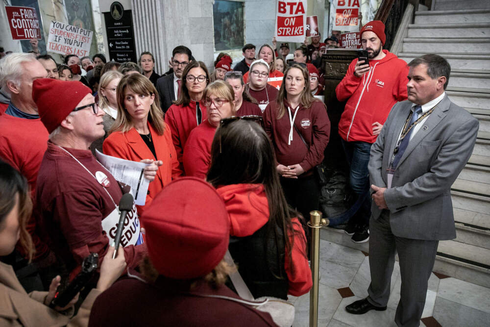 Teachers from various North Shore schools speak with Gov. Healey's labor advisor Roger Brunelle at the Massachusetts State House. (Robin Lubbock/WBUR)
