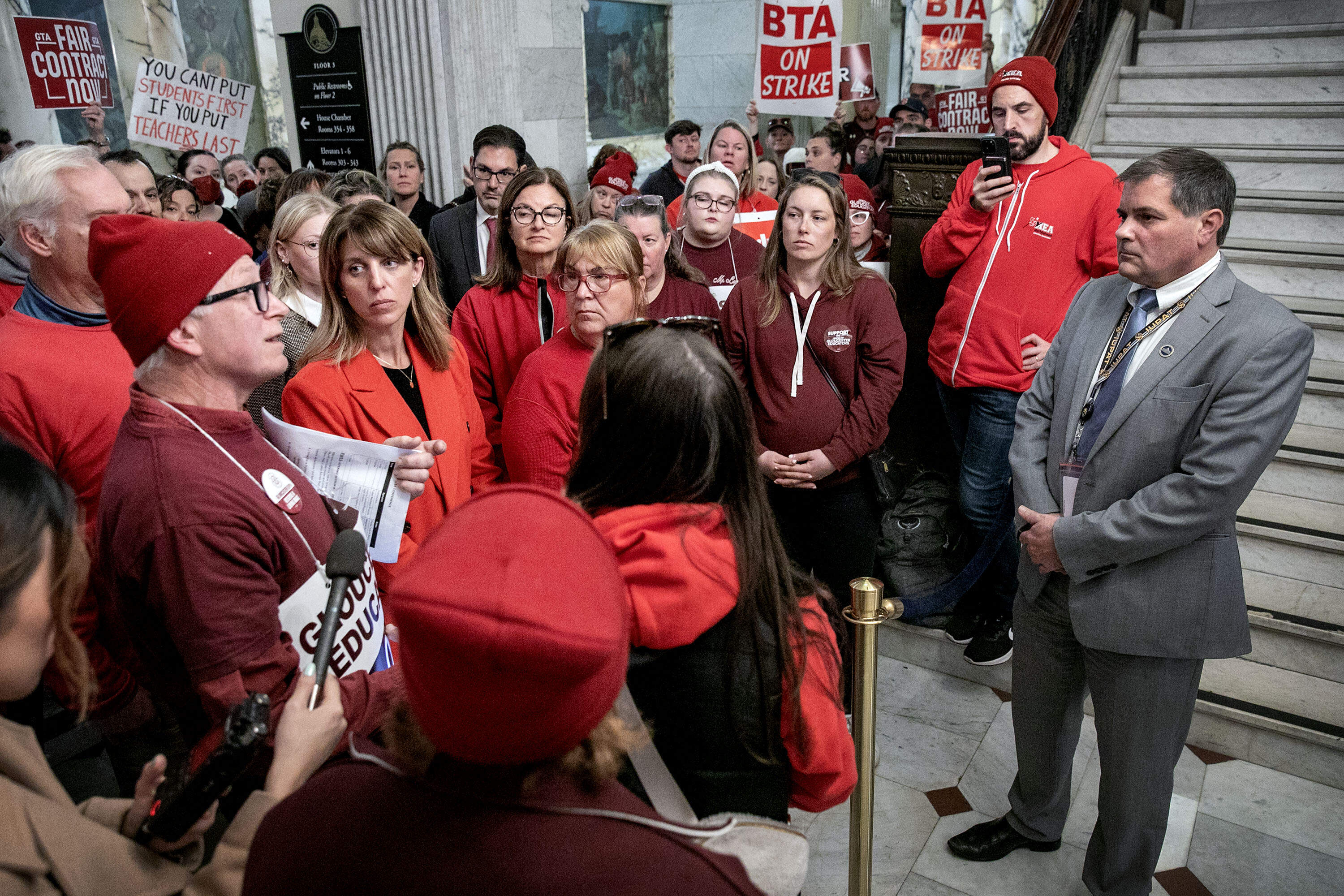 Teachers from various North Shore schools speak with Gov. Healey's labor advisor Roger Brunelle at the Massachusetts State House. (Robin Lubbock/WBUR)