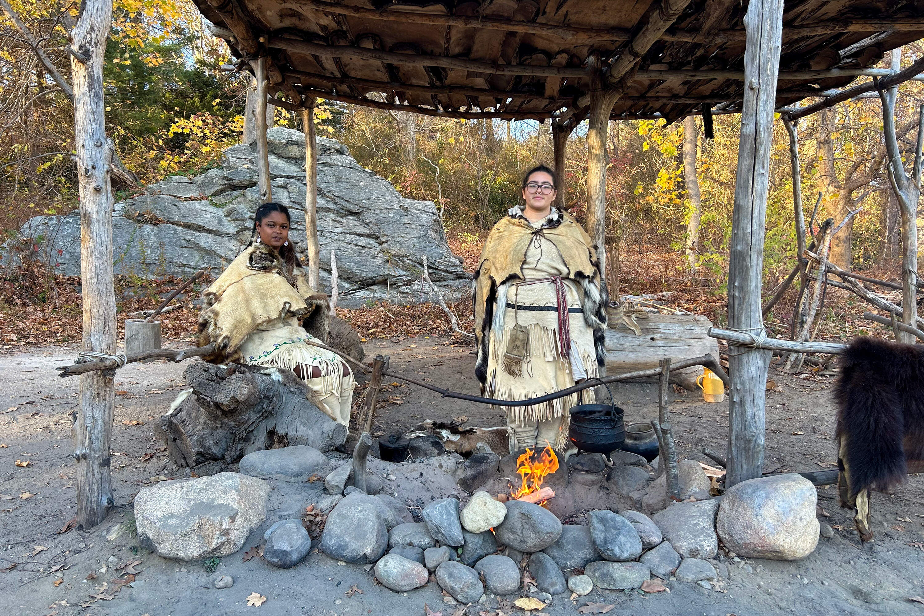 From left, Alyssa Harris and Kuwah Deetz at the Plimouth Patuxet Museums Wampanoag house site. (Amanda Beland/WBUR)