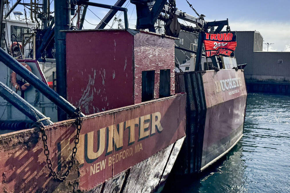 A Trump flag flies off the back of a scallop boat in New Bedford harbor. (Walter Wuthmann/WBUR)