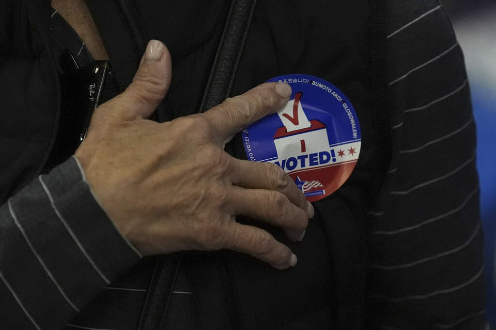 A person attaches a "I Voted" sticker to their shirt on Thursday, Oct. 3, 2024, in Chicago. (Charles Rex Arbogast/AP)