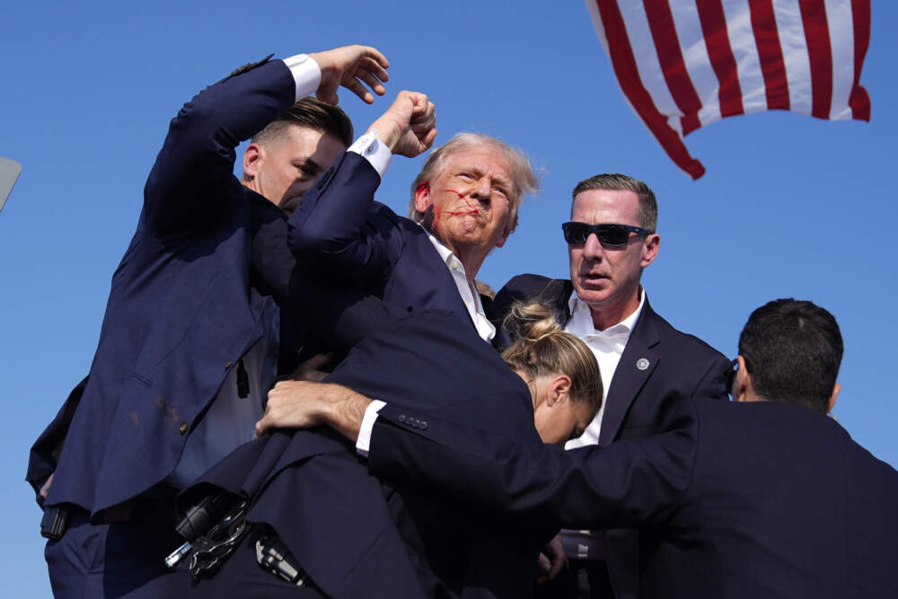 Republican presidential candidate former President Donald Trump is surrounded by U.S. Secret Service agents on July 13, 2024, in Butler, Pennsylvania. (Evan Vucci/AP)