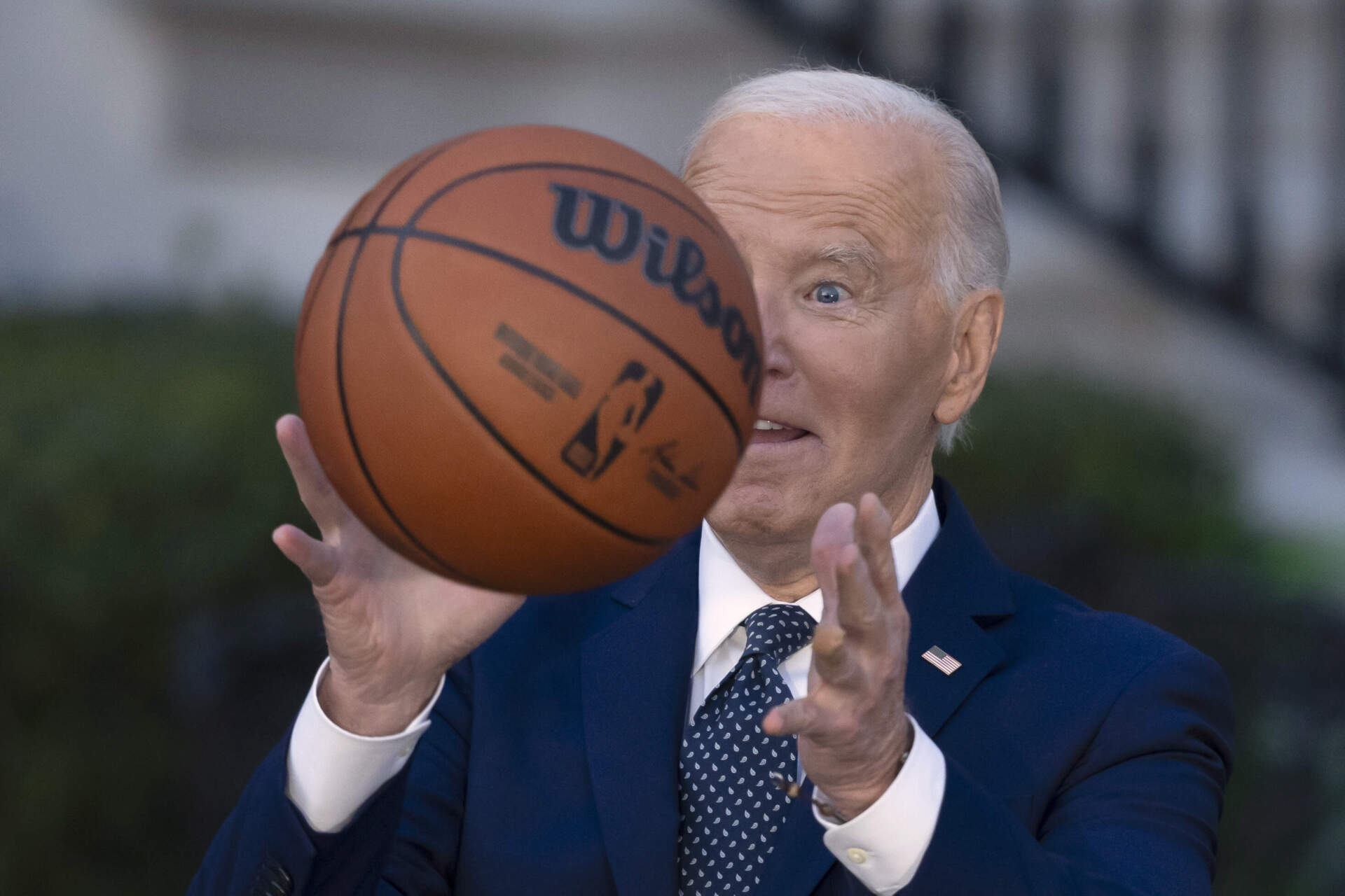 President Joe Biden throws a basketball he received from the Boston Celtics at an event to celebrate the team's victory in the 2024 NBA Championship. (Ben Curtis/AP)