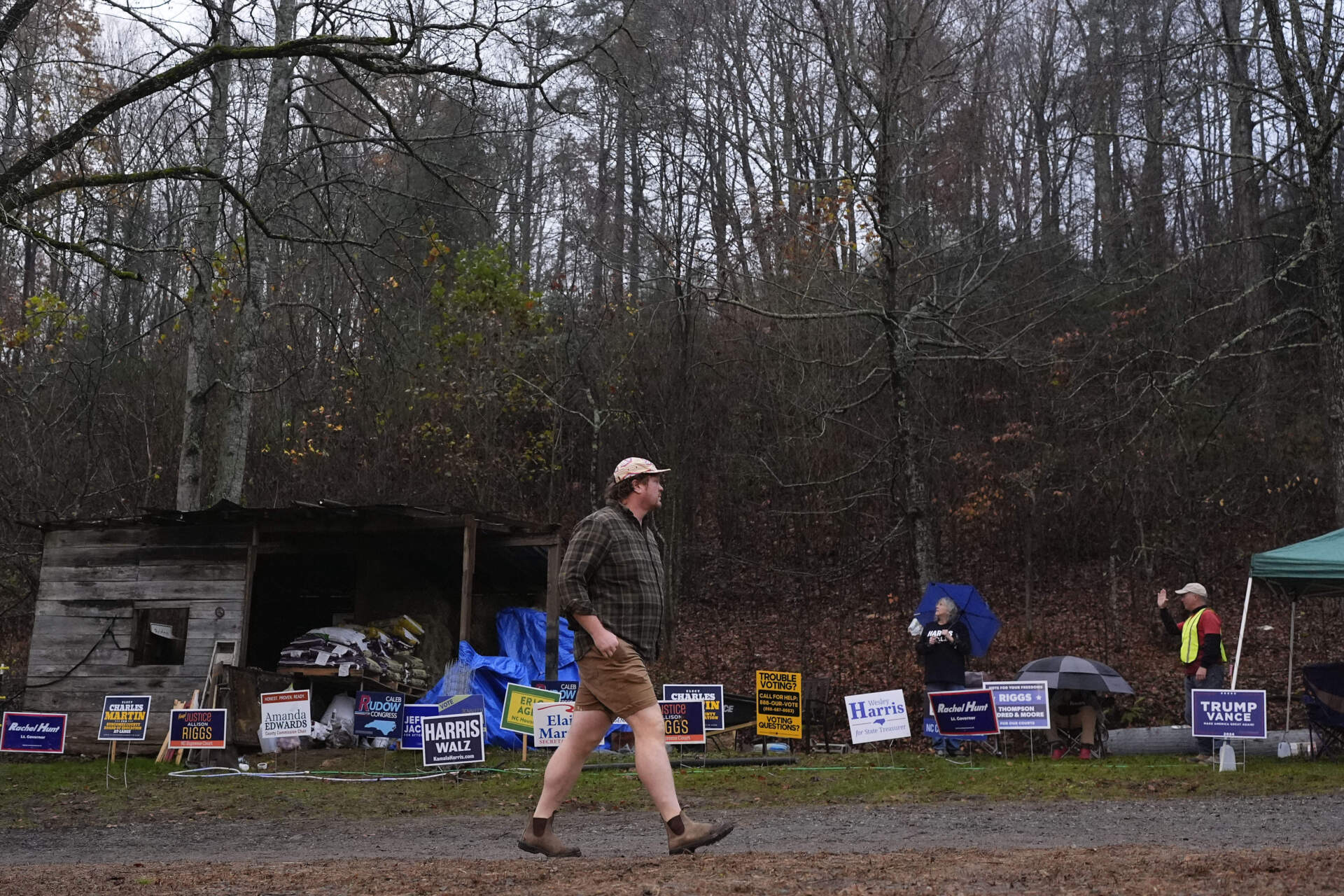 Greg Remter passes a row of campaign signs as he walks to a polling place in Black Mountain, N.C. (George Walker IV/AP)