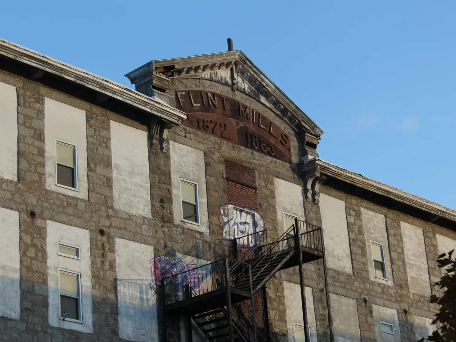 The Flint Mills gave the neighborhood its name, but the building has been abandoned for years. (Ben Berke/The Public’s Radio)