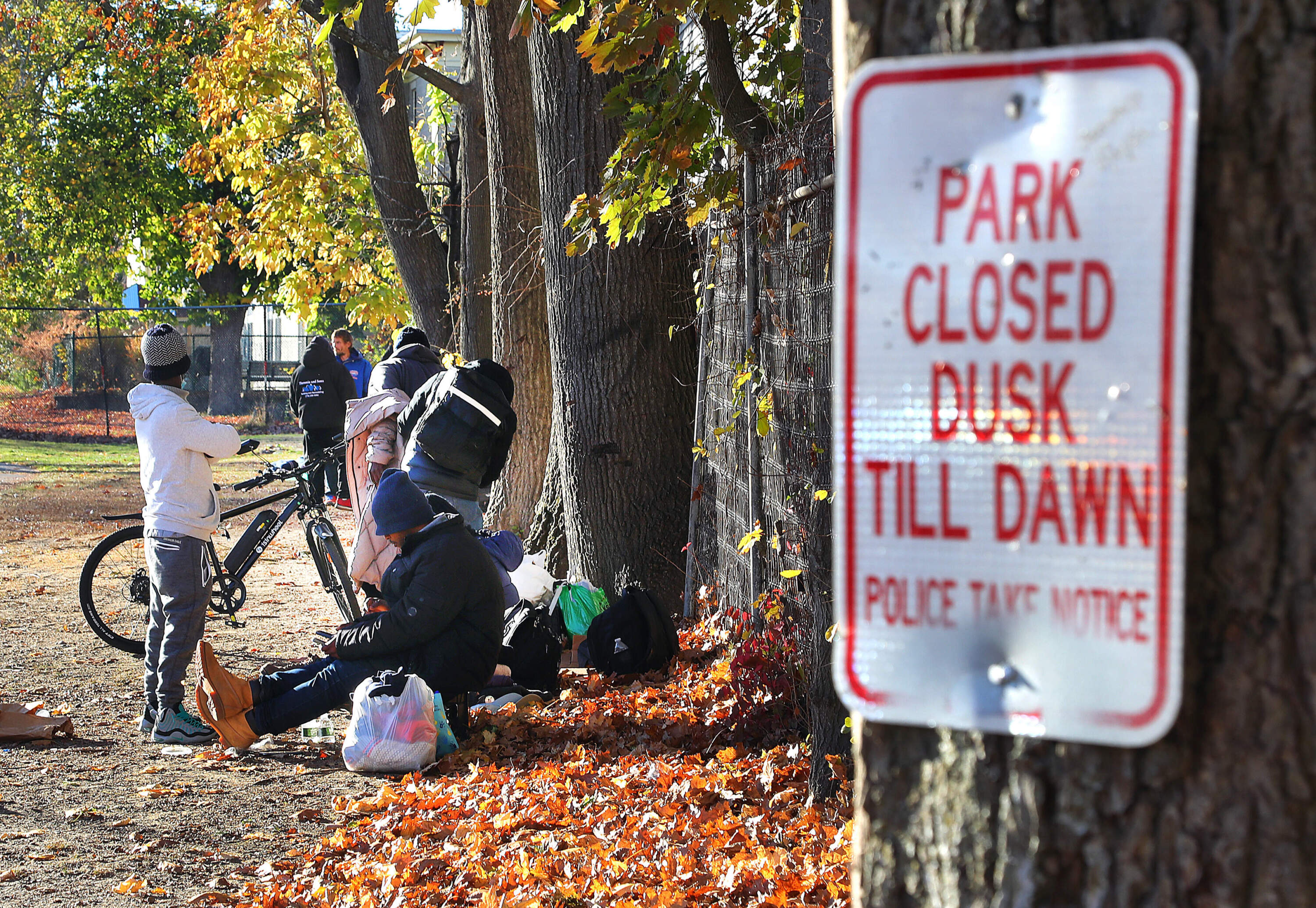 People sit in Perkins Park on North Main Street in Brockton, a popular location for those struggling with homelessness to set up encampments. (John Tlumacki/The Boston Globe via Getty Images)