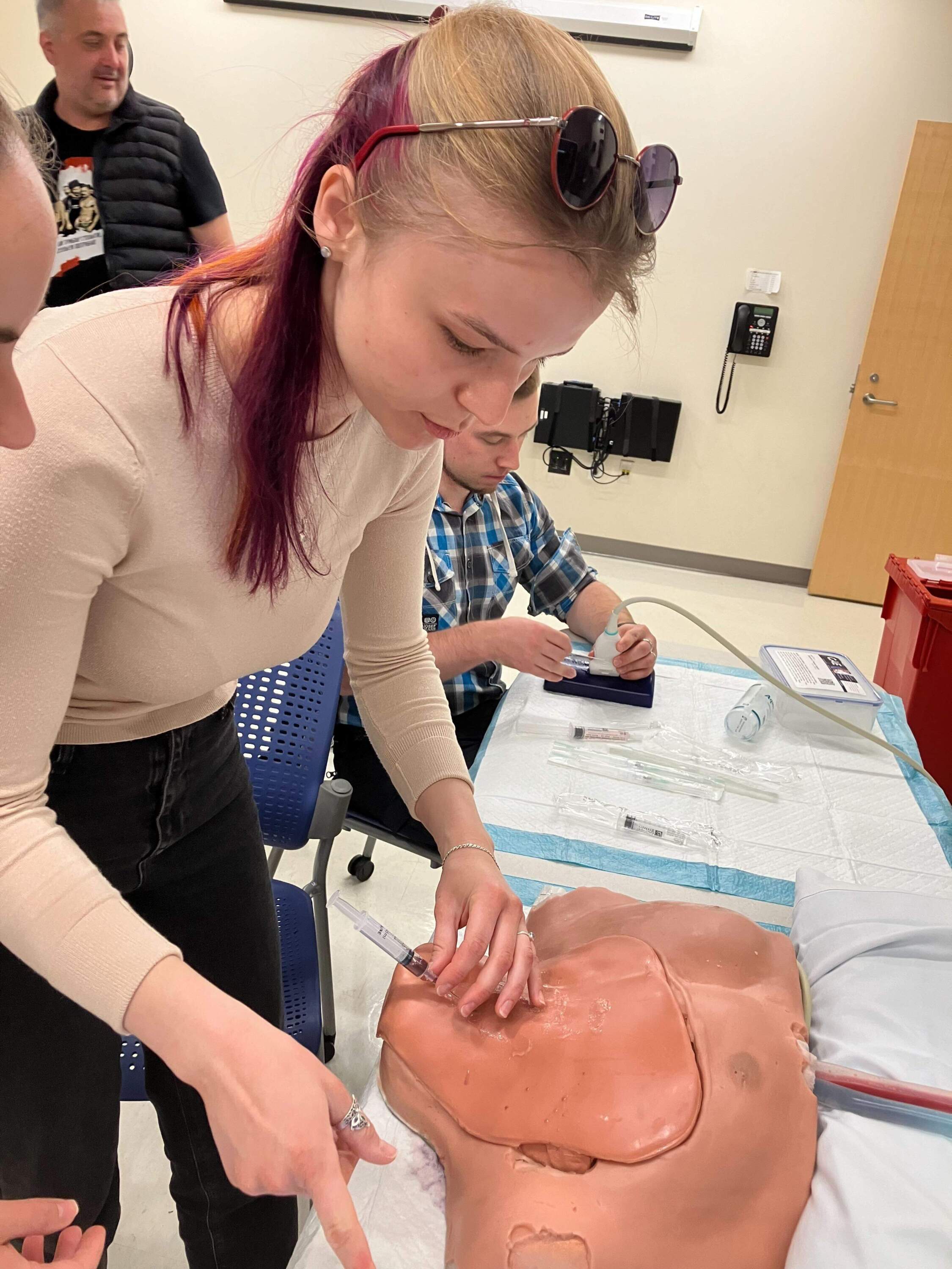 Victoria Totkalova practices a an ultrasound guided central line placement on a simulation neck/torso. (Karyn Miller-Medzon/Here &amp; Now)