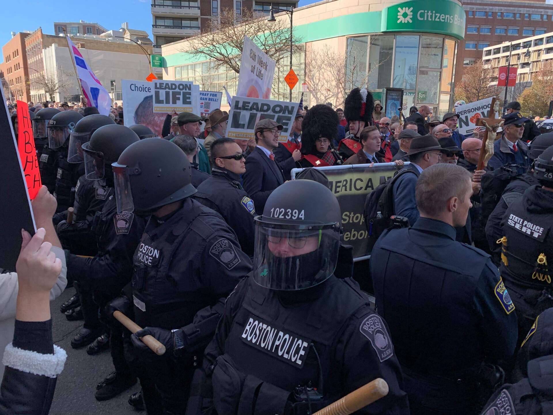 A line of police in riot gear stand between anti-abortion marchers and counter-protesters.