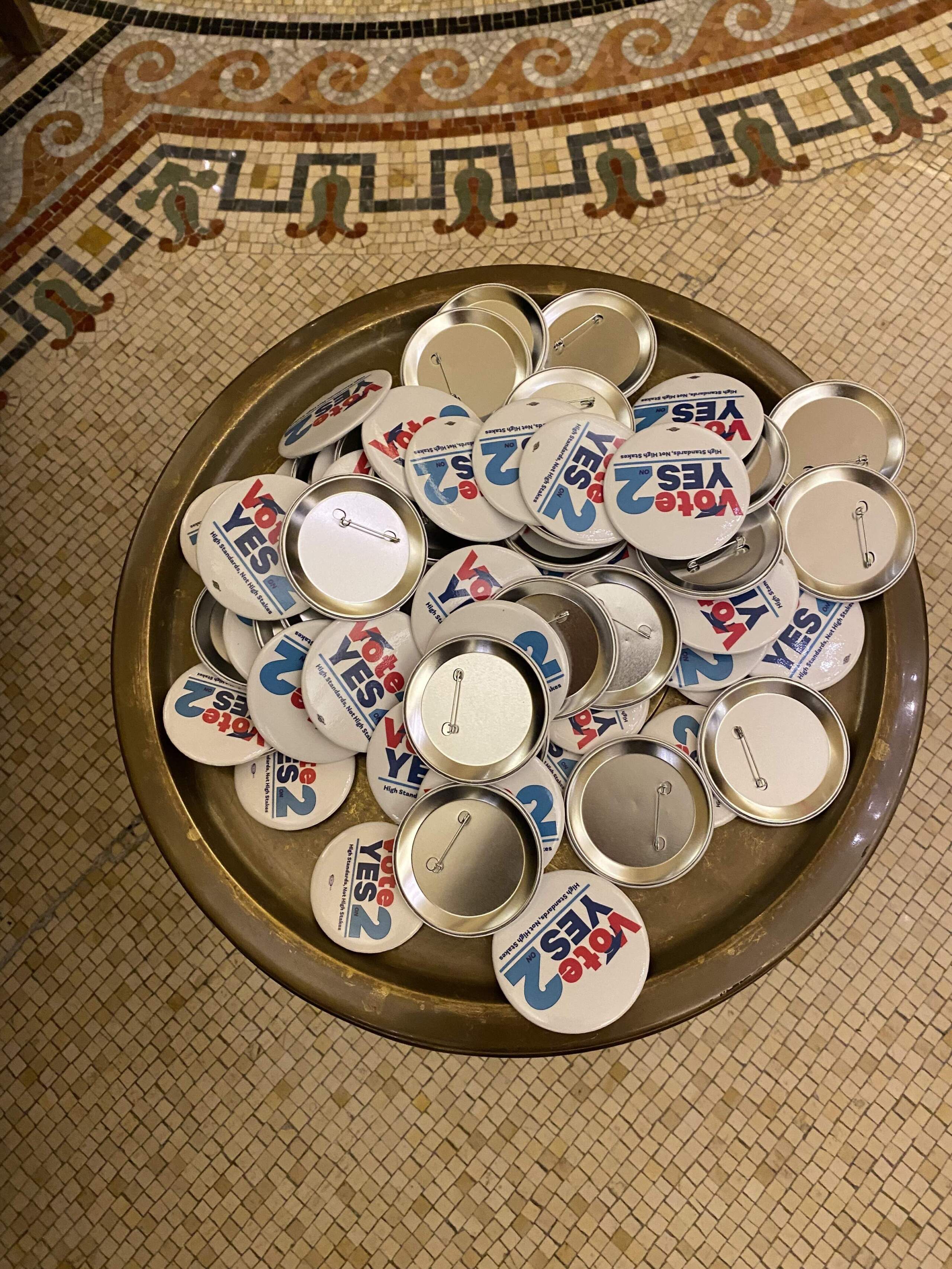 A tray filled with "Yes on 2" pins at the Massachusetts Teachers Association election night event. (Suevon Lee/WBUR)