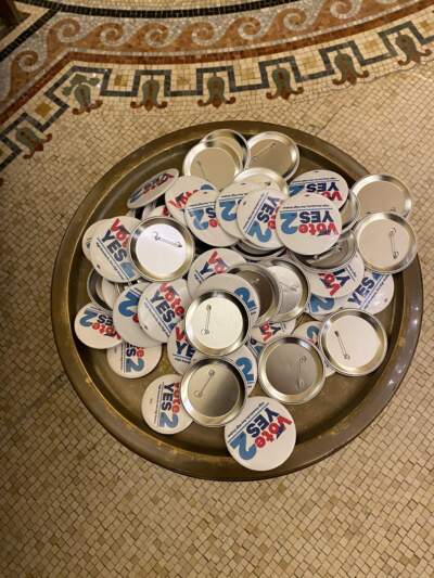 A tray full of "Yes at 2" Needles at the Massachusetts Teachers Association election night event. (Suevon Lee/WBUR)