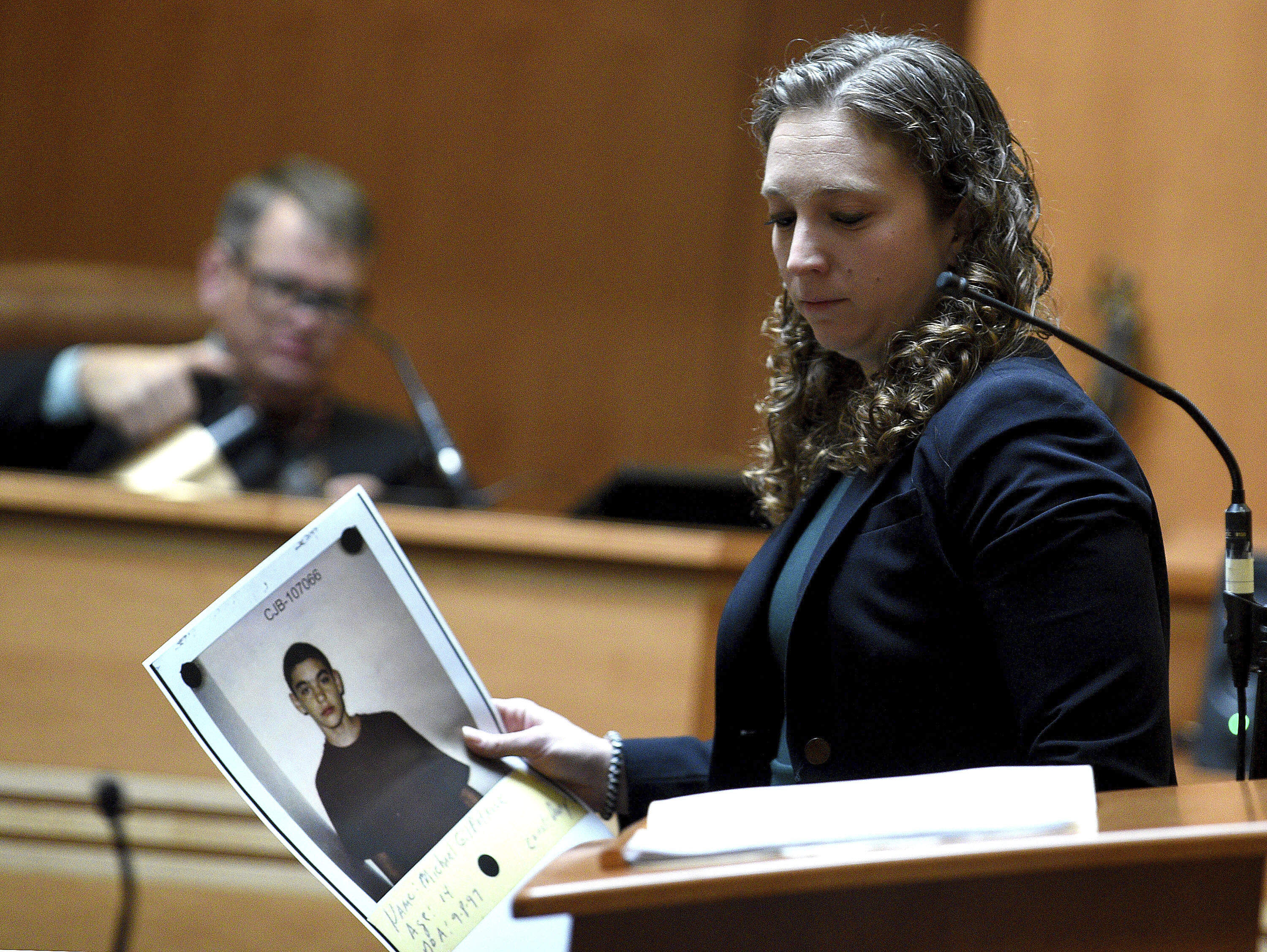 Assistant Attorney General Audriana Mekula holds a picture of Michael Gilpatrick when he was 14 that she showed the jury during opening statements in the trial of Bradley Asbury at Hillsborough County Superior Court in Manchester, N.H.,, Tuesday, Nov. 19, 2024. (David Lane/Union Leader via AP)