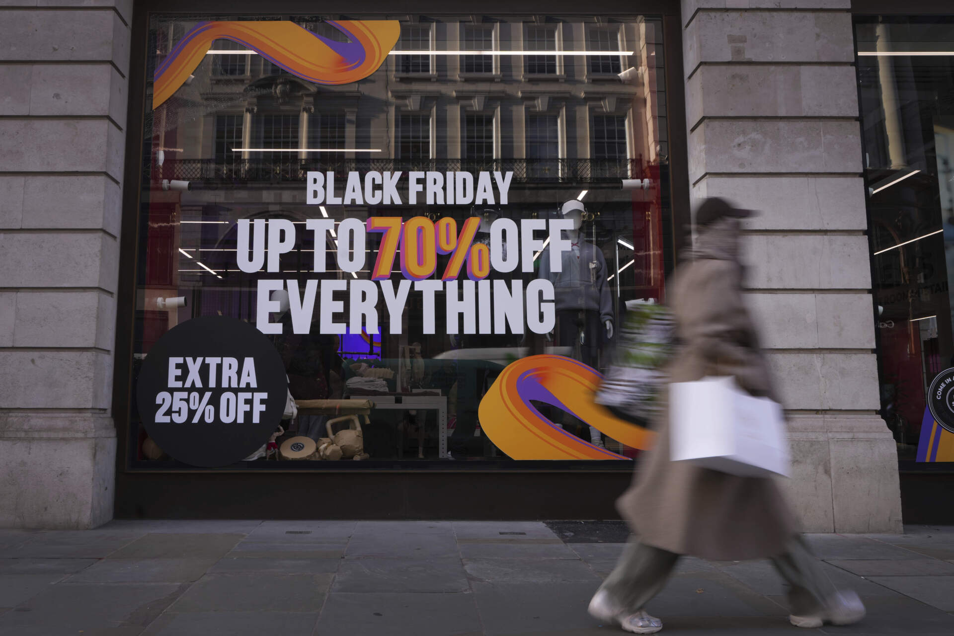 A shopper passes a store advertising a Black Friday Sale on Regent Street in London on Nov. 28. (Kirsty Wigglesworth/AP)