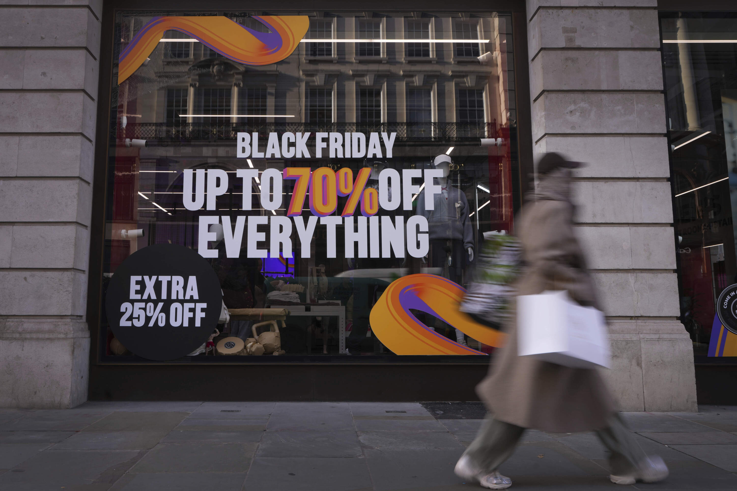 A shopper passes a store advertising a Black Friday Sale on Regent Street in London on Nov. 28. (Kirsty Wigglesworth/AP)