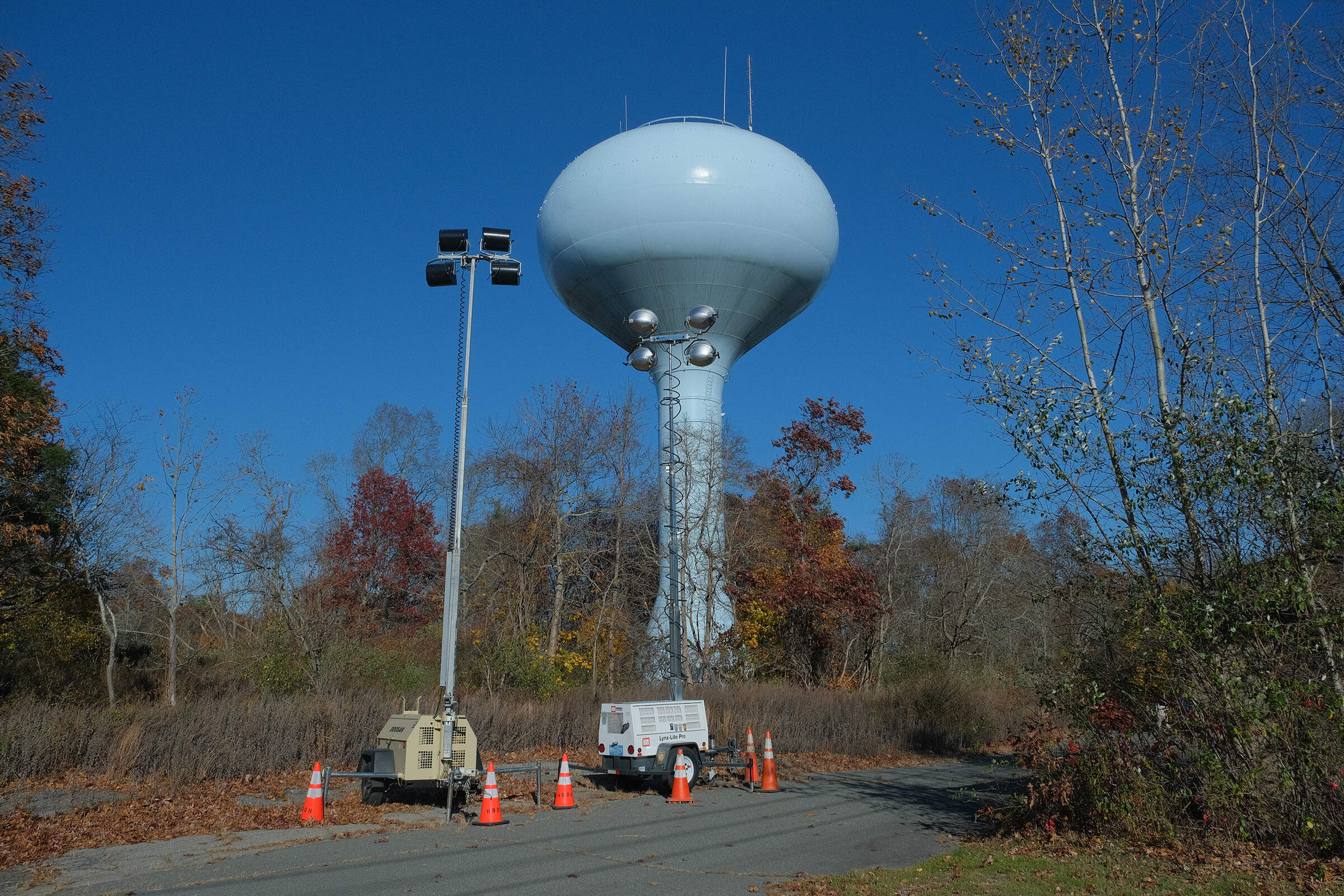 The municipal water tower in Hanson that has been the canvas for a Trump-Punisher symbol and a Trump 2024 logo. (Patrick Madden/WBUR)
