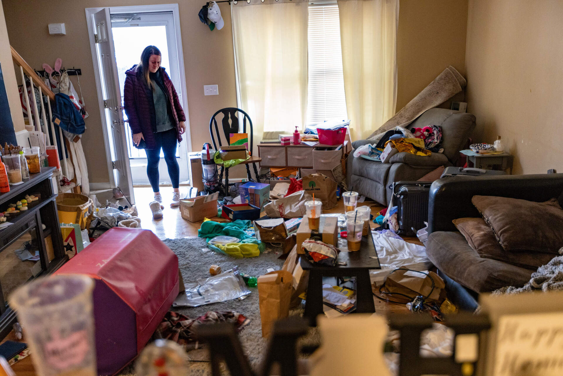 Taylor Avitabile, a landlord, looks disgusted as she surveys the damage of the rental apartment a tenant left with trash and damaged property strewn everywhere. (Jesse Costa/WBUR)