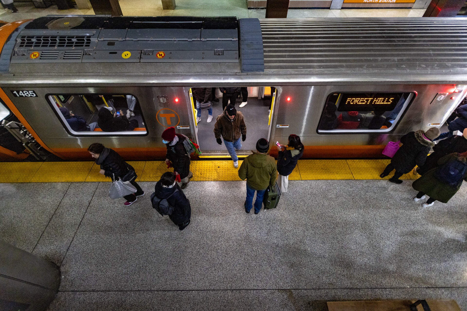 MBTA riders get on and off an Orange Line train in North Station.