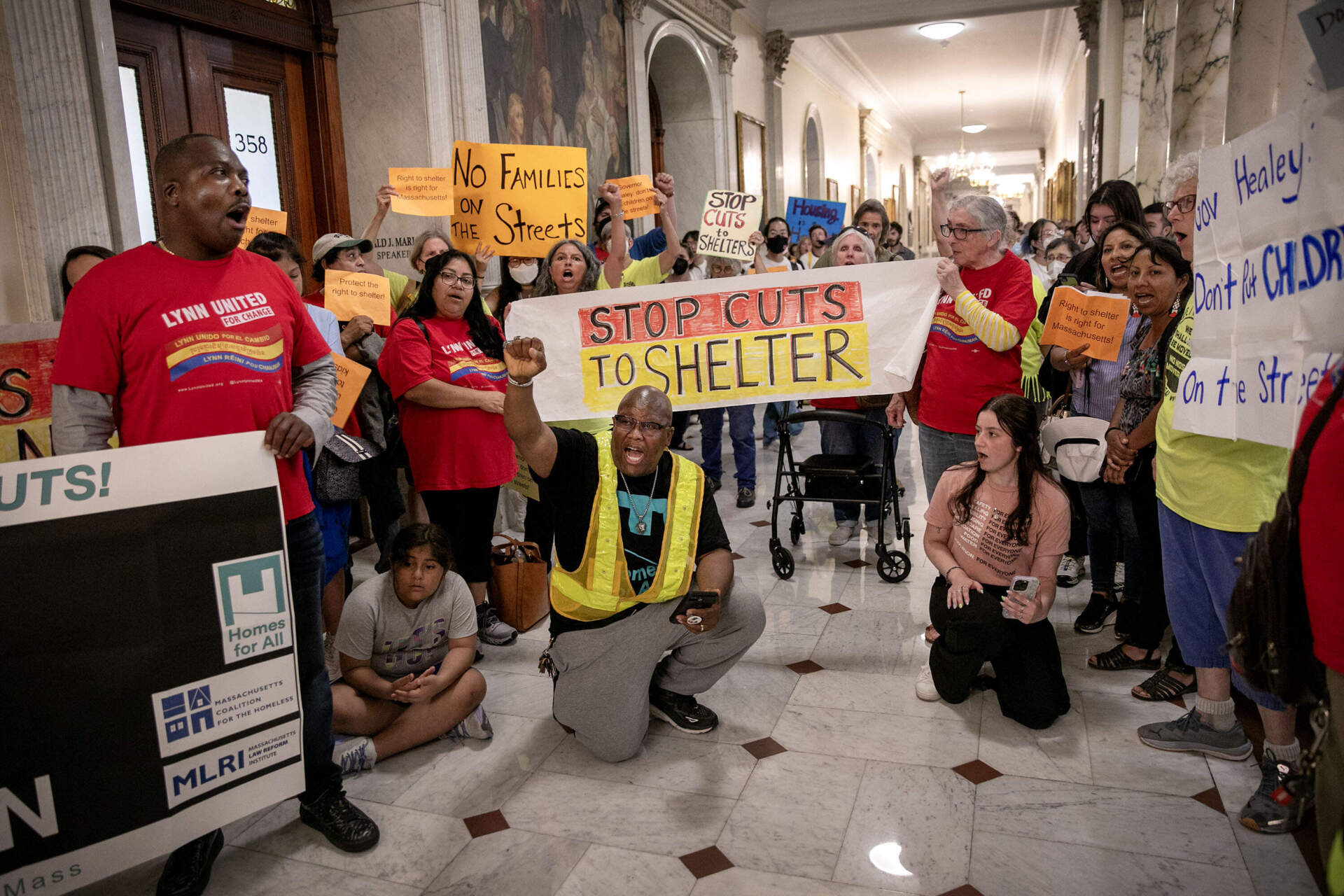 Protesters outside the Executive Office at the Massachusetts State House, call on Governor Maura Healey to reconsider new restrictions to the family shelter system.