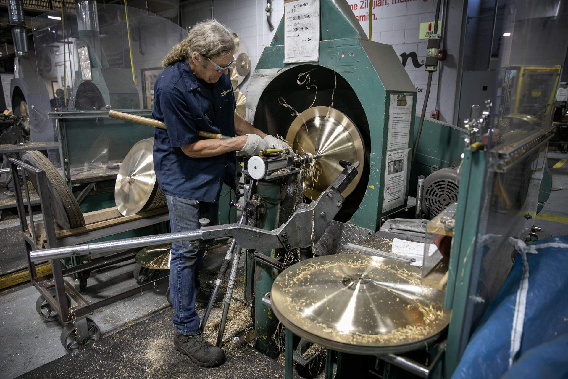 Cymbalsmith Peter Nelson works on a cymbal on a lathe at the Zildjian cymbal factory in Norwell, Mass. (Robin Lubbock/WBUR)