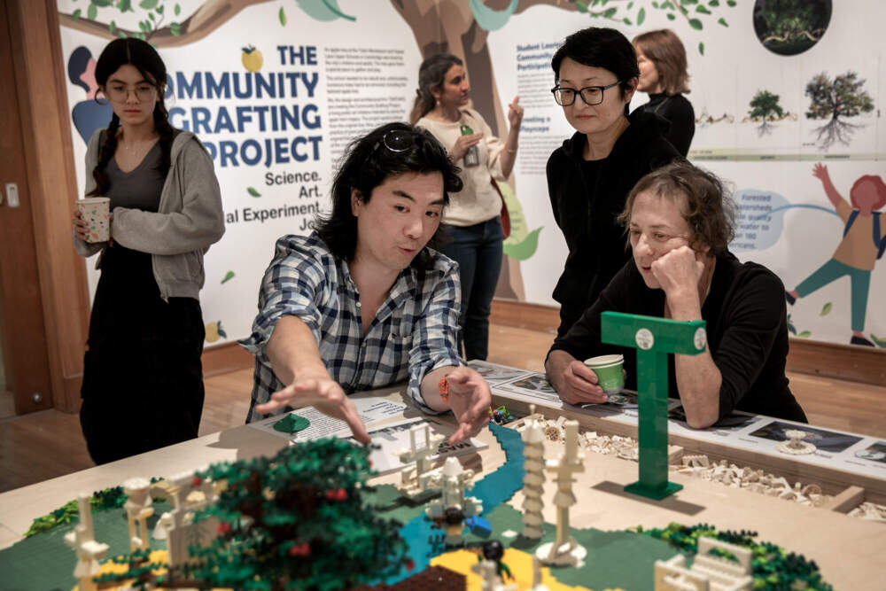 Yugon Kim and Tomomi Itakura, of TSKP x ikd, talk with a visitor to the The Community Grafting Project exhibit at Gallery 344 in Cambridge. (Robin Lubbock/WBUR)