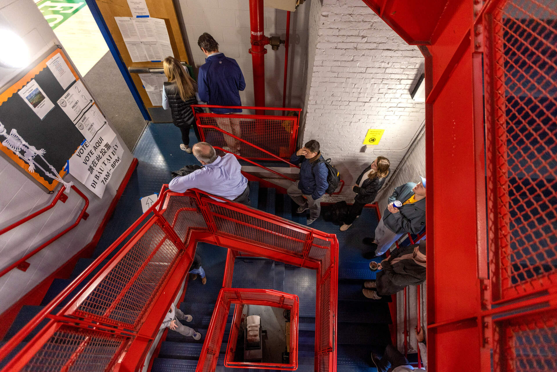 Voters wait in a long line down a spiral staircase before the polls open at 7 a.m. at the Charlestown Boys and Girls Club in Boston on Nov 5, 2024.