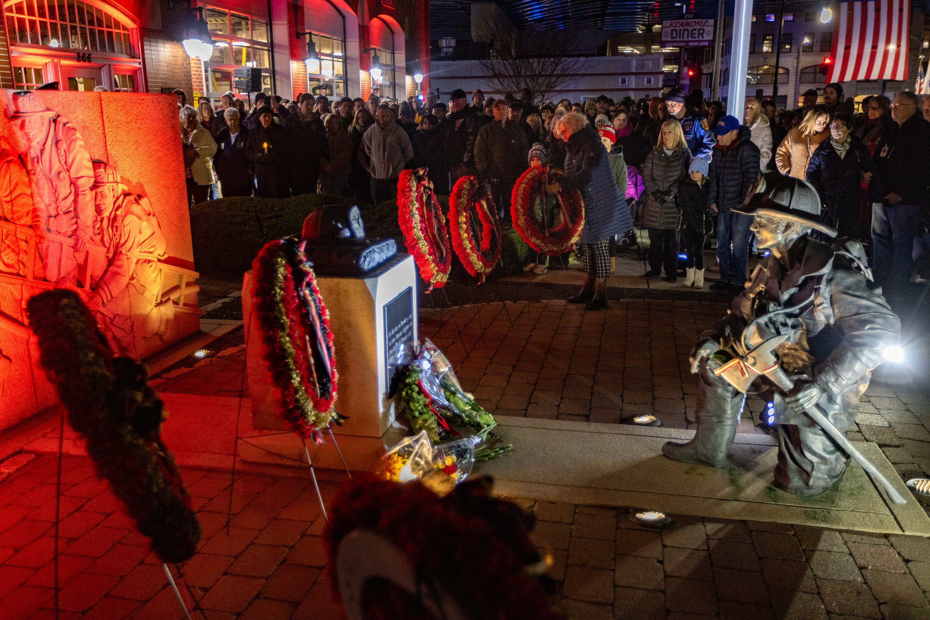 The final of six wreaths, representing the six firefighter who died, is placed onto the Worcester Cold Storage and Warehouse fire Memorial at the Franklin Street Firehouse. (Jesse Costa/WBUR)
