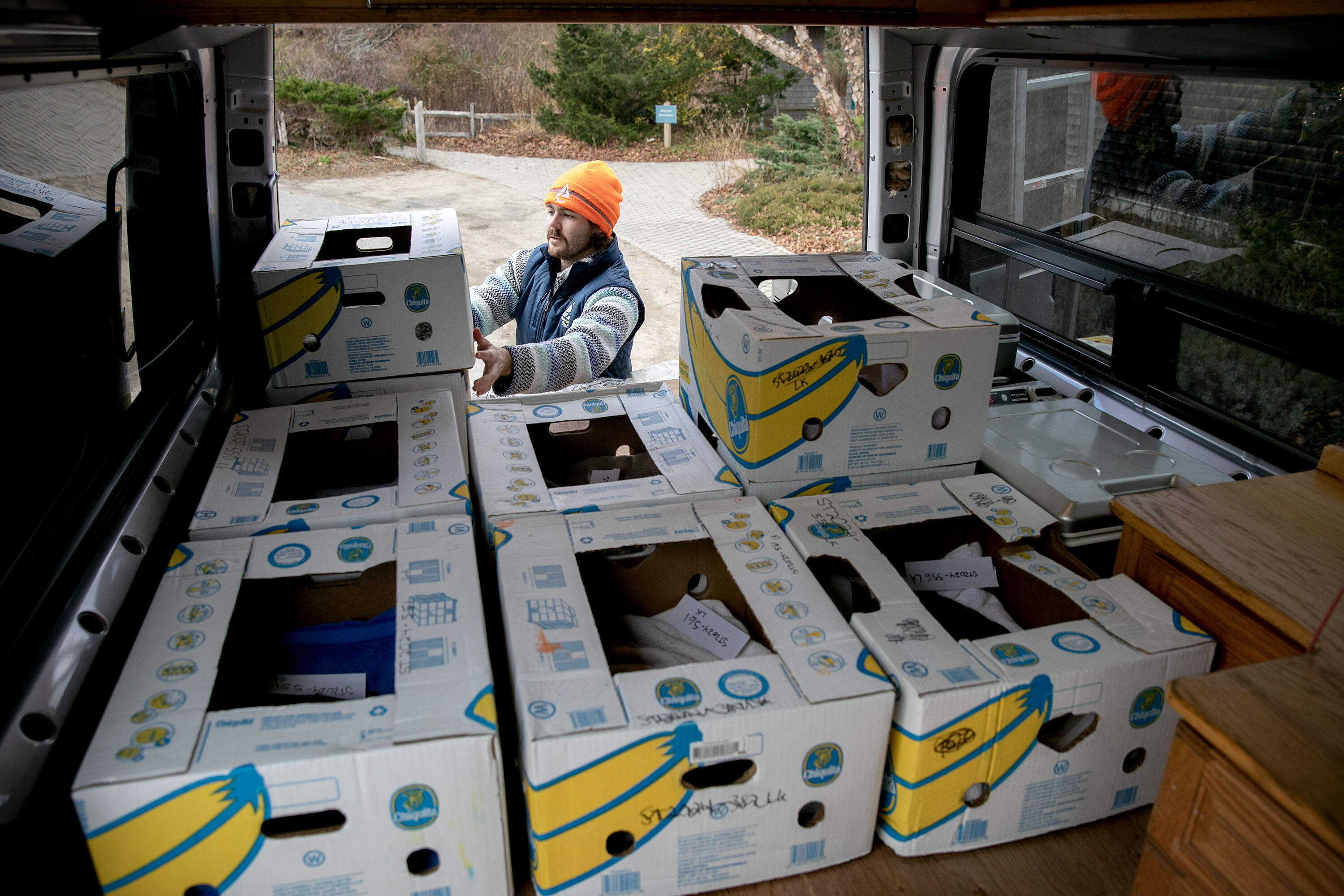 Mass Audubon Volunteer Coordinator Ben Chester loads turtles in banana boxes into a van, at the Wellfleet Bay Wildlife Sanctuary. (Robin Lubbock/WBUR)
