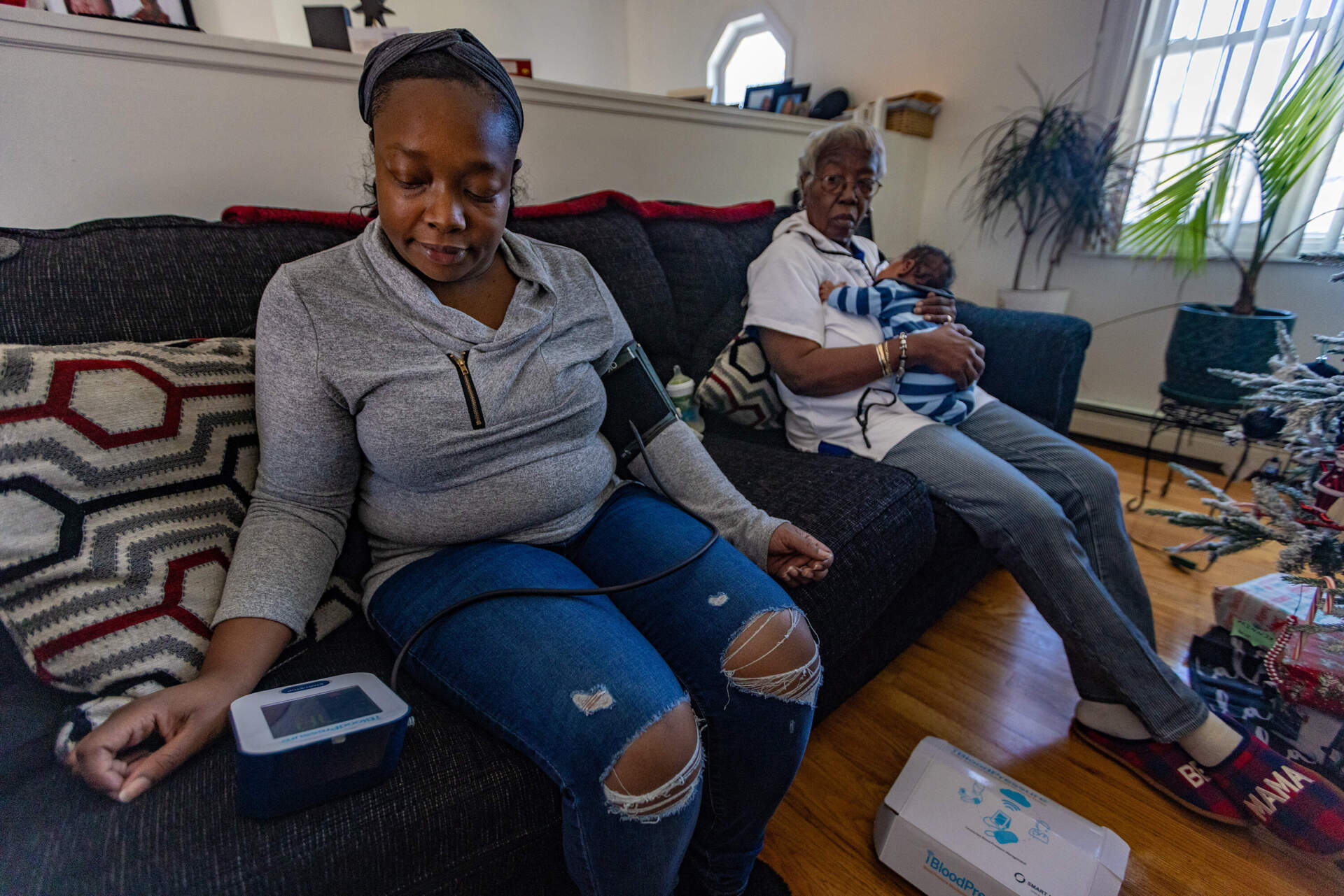 Boston Medical Center patient Kennise Nevers, her mother, Nancy Josey, and her son, AJ. Nevers monitored her blood pressure at home in the weeks after giving birth to AJ in October 2022. (Jesse Costa/WBUR)