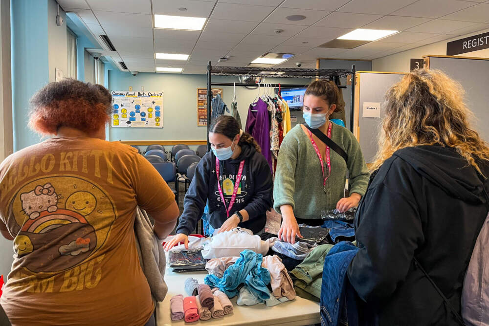 Women pick out clothing at the HER Saturday event run by Boston Health Care for the Homeless Program. (Lynn Jolicoeur/WBUR)