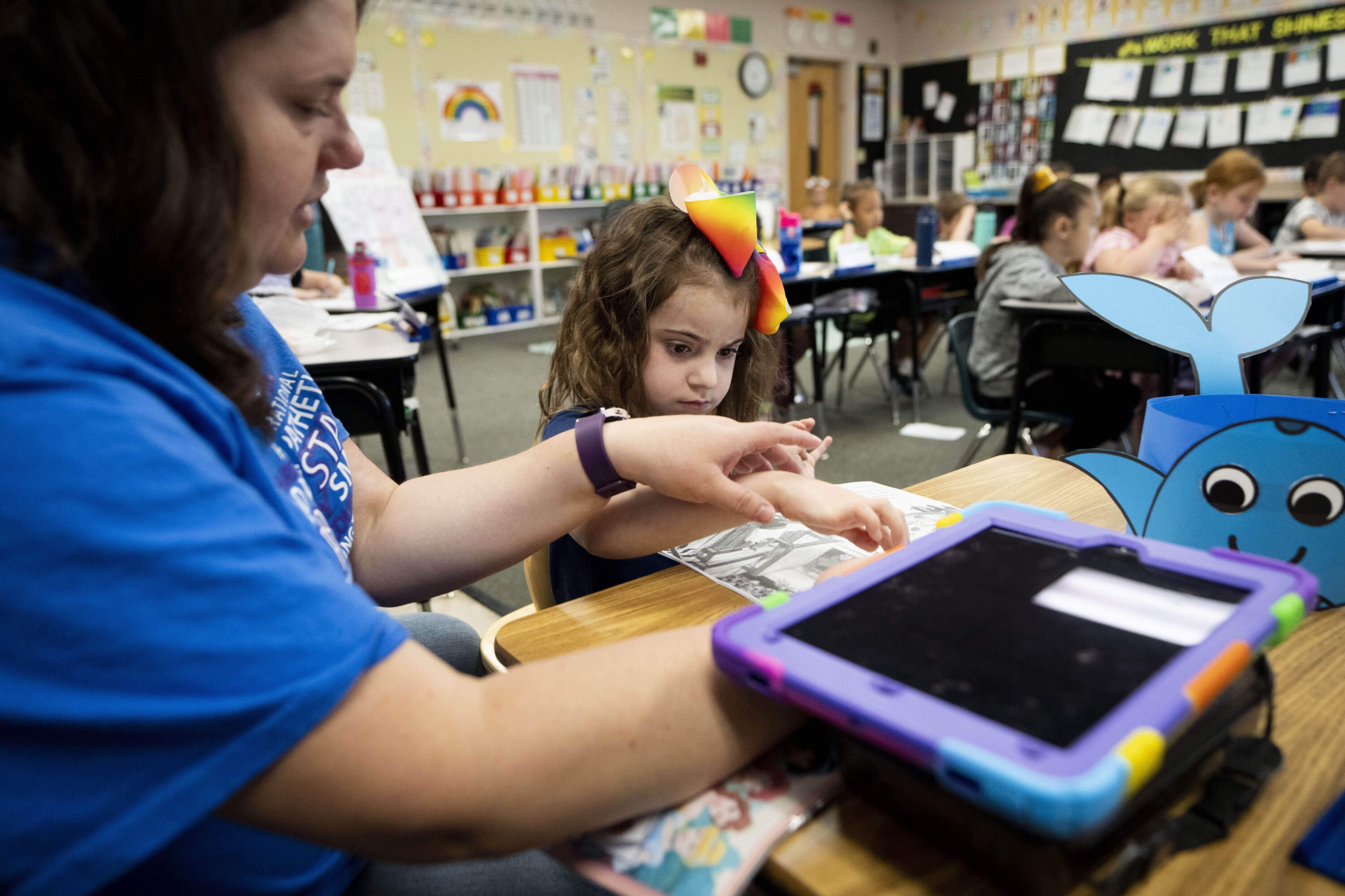 Vivien Henshall, a long-term substitute special education teacher, works with Scarlett Rasmussen separately as other classmates listen to instructions from their teacher at Parkside Elementary School on Grants Pass, Oregon. (Lindsey Wasson/AP)