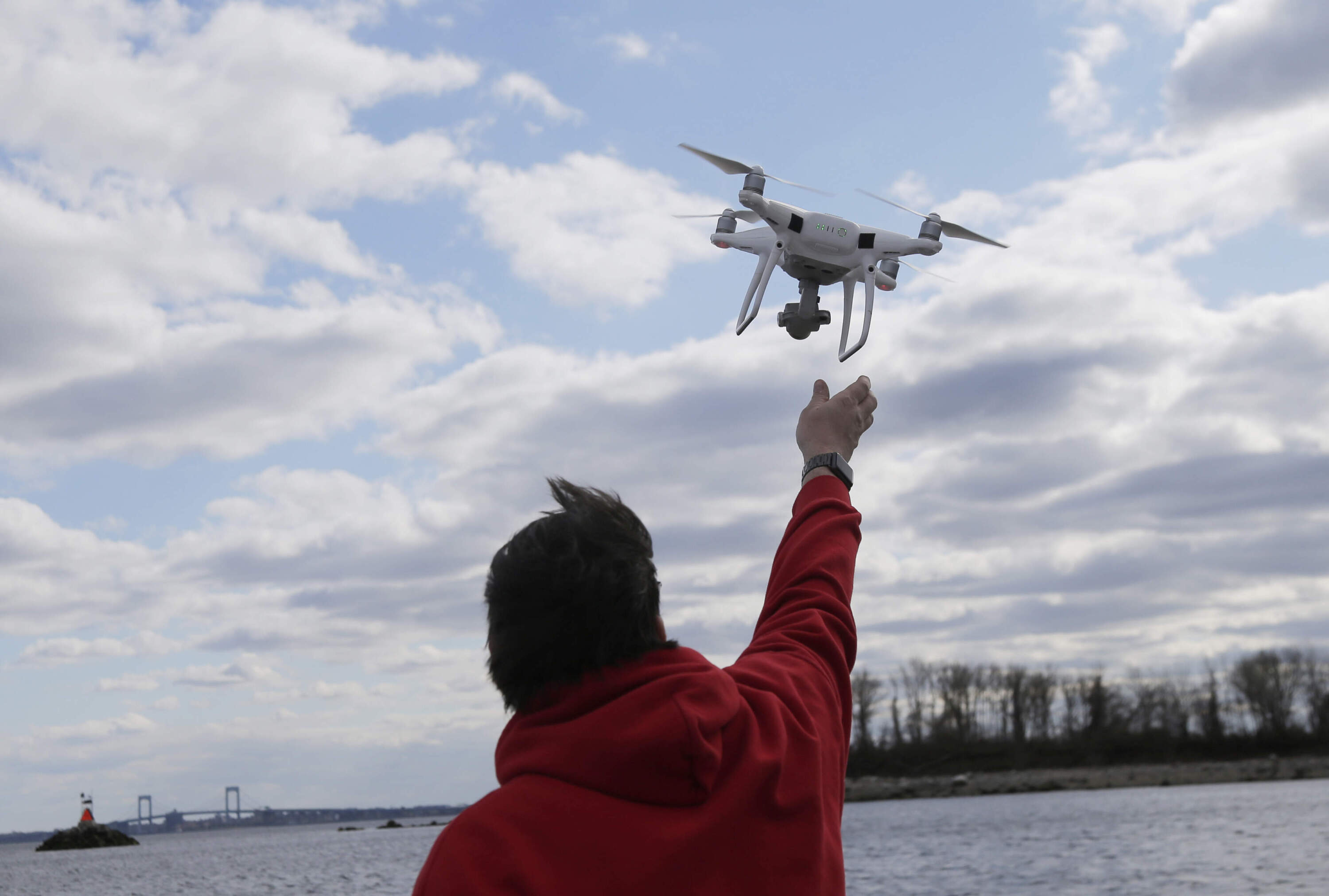 A drone operator helps to retrieve a drone after photographing over Hart Island in New York. (Seth Wenig/AP)