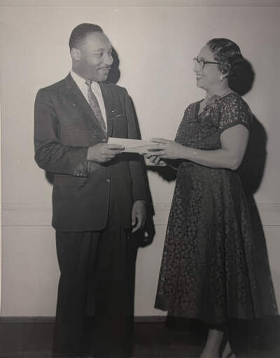 Martin Luther King Jr. was honored at a Freedom House luncheon in 1958. Here, Margaret Moseley hands him a check to put towards his civil rights efforts.(Courtesy Northeastern University Archives)